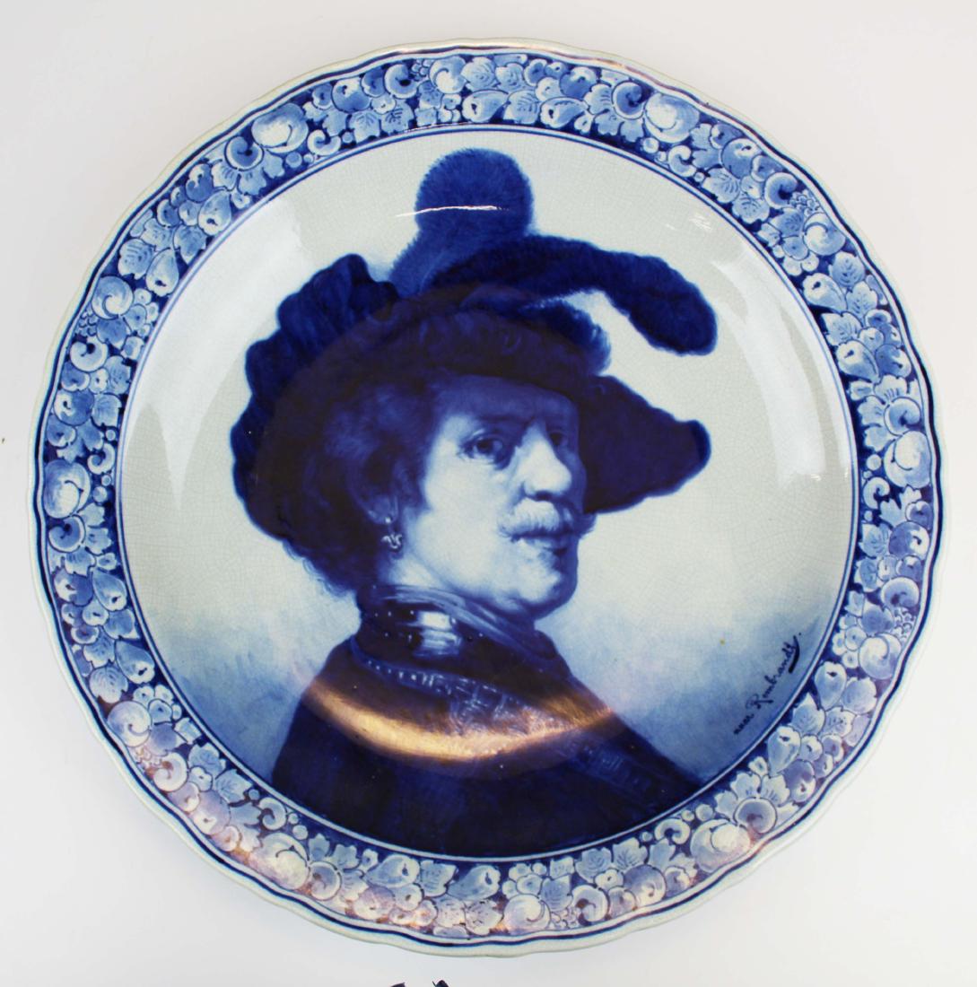2 Delft blue and white pottery chargers: 2 early 20th c. Delft blue and white pottery chargers including Joost Thooft and Labouchere charger with Old Master style portrait of a gentleman after Rembrandt, the second with harbor scene of sail