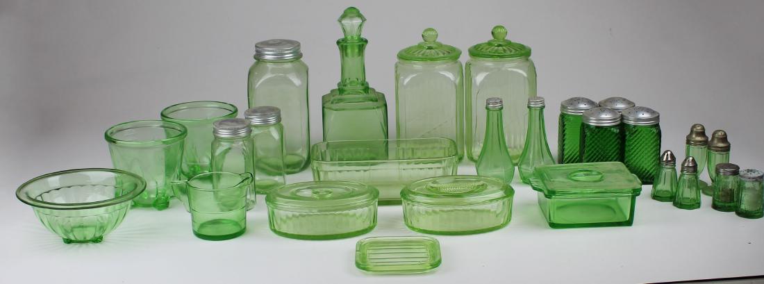 Green Depression glass kitchen glassware: group of green Depression era glass kitchen glassware including cannisters, range shakers, refrigerator ware, mixing bowls etc. some pieces with chips, one large cannister cracked