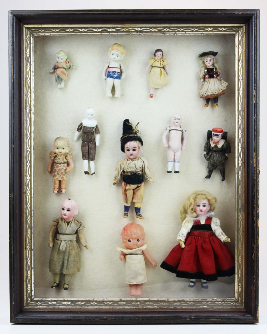 shadow framed case of small dolls: shadow framed case of small dolls- bisque, china, celluloid (12 pcs- 3 1/2" to 6 1/2"), presented as the collector had displayed them, overall size 20 1/2" x 16 1/2"