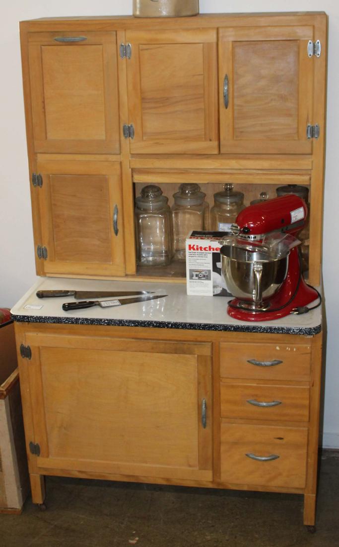 Hoosier two part kitchen cabinet.: Two part basswood Hoosier cabinet. Upper section with roll door and flour bin, enamel shelf, and lower section with door and 3 drawers. Refinished and cleaned.