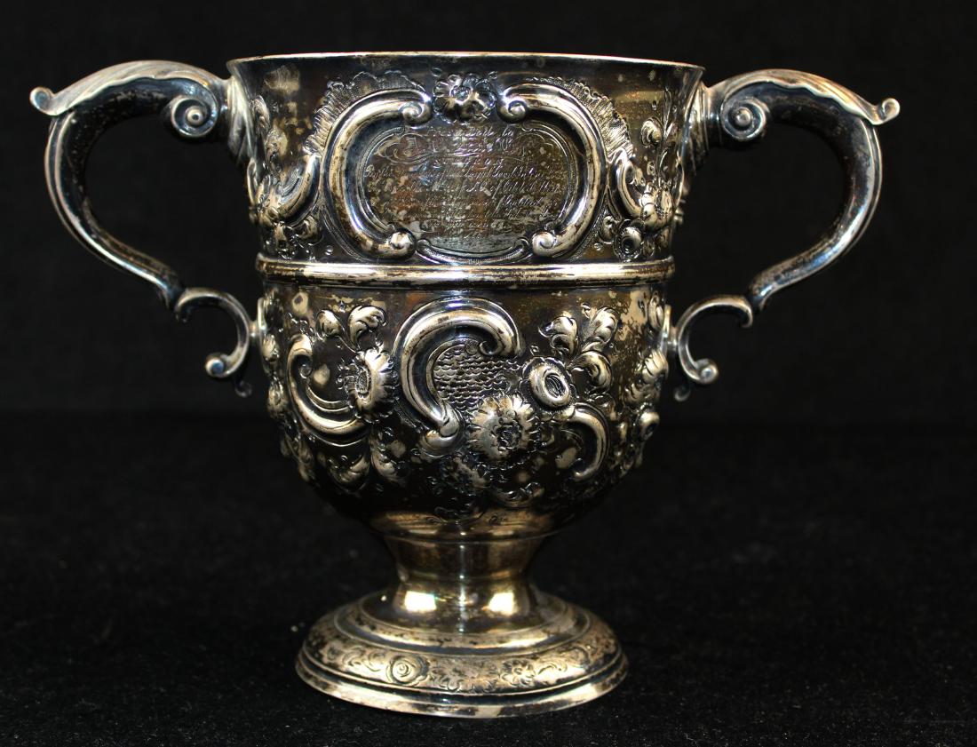 18th c. Dublin sterling silver handled loving cup: 18th c. Dublin Georgian form sterling silver double handled loving cup with mid-19th c. hand chased rococo style floral decoration, having cartouches on either side, one bearing inscription "Presented