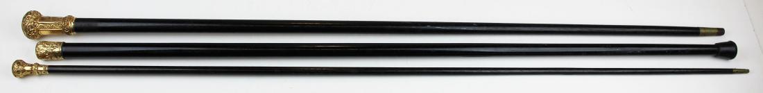 three Victorian rolled gold headed canes: three Victorian rolled gold capped canes, ebonized shafts, lengths 34 1/2" to 36"