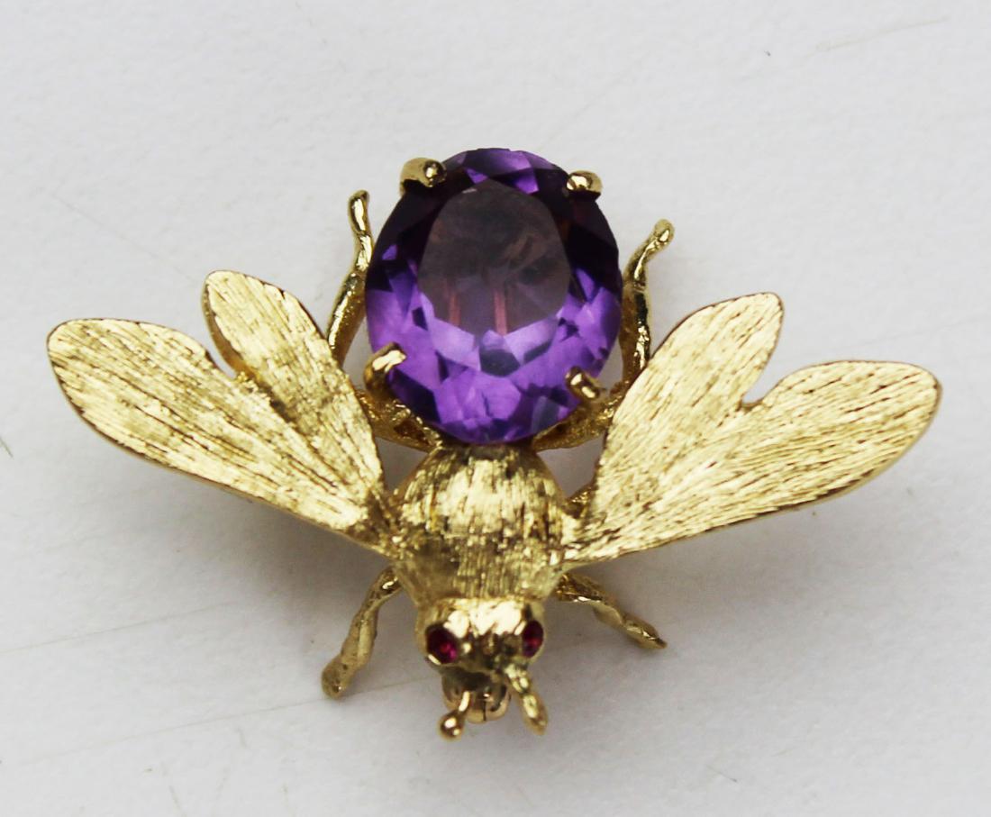 14k yellow gold, amethyst, & ruby bee pin: Mid 20th c figural bee or bug brooch pin set with a oval cut amethyst body and ruby eyes. 14k yellow gold. 6.4 grams t.w. 1" long.