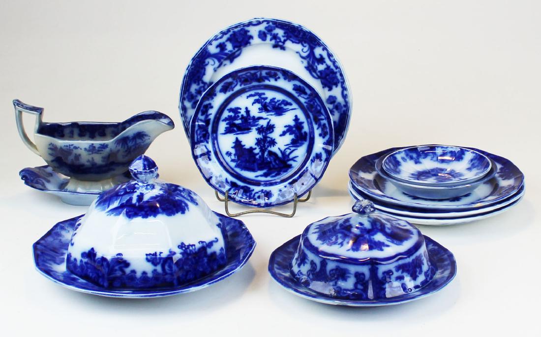 12 pcs. Flow blue cobalt ironstone porcelain: 12 pcs. Flow blue cobalt transferware decorated ironstone porcelain including plates, domed lids, sauce boat and undertray, saucers, etc. -some chips on plates, sauce boat with hairline check