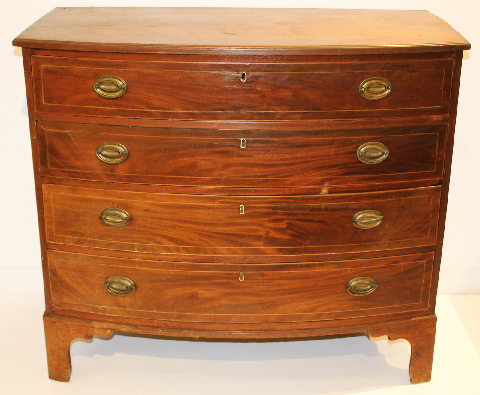 19th c. Hepplewhite cherry bow front chest: 19th c. Hepplewhite cherry string inlaid bow front chest with original brasses, likely VT, missing portions of rear leg, restorations to top 39.5"w.