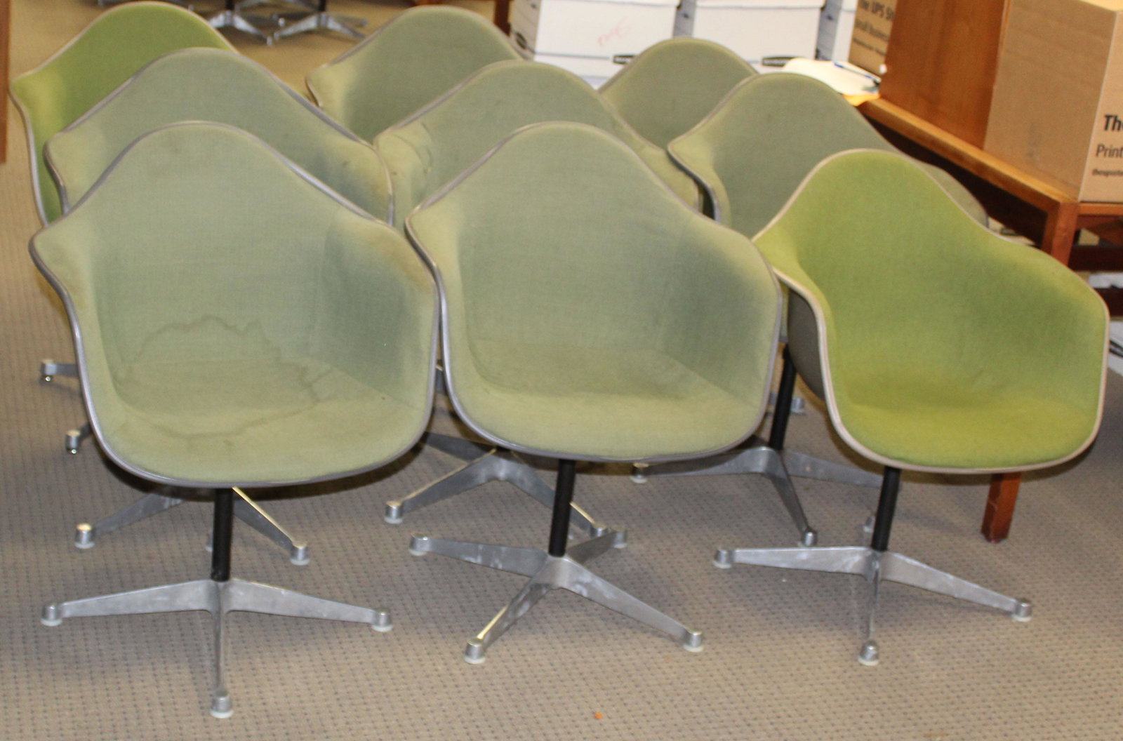 Nine green Herman Miller chairs: Nine Charles and Ray Eames designed Herman Miller "La Fonda" mid- century industrial shell chairs in green upholstery most marked Feb 1970 some with GMC LIB etched beneath