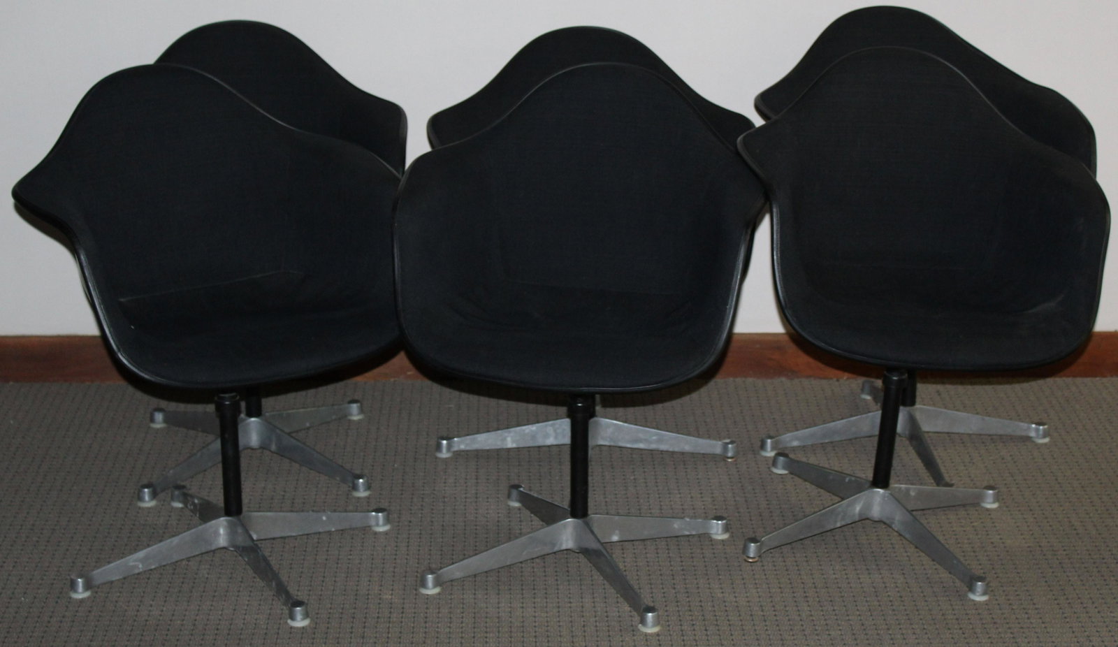Six Black Herman Miller Chairs: Six Charles and Ray Eames designed Herman Miller "La Fonda" mid-century industrial shell chairs in black upholstery most marked FEB 1970 some with GMC LIB etched on underside of shell