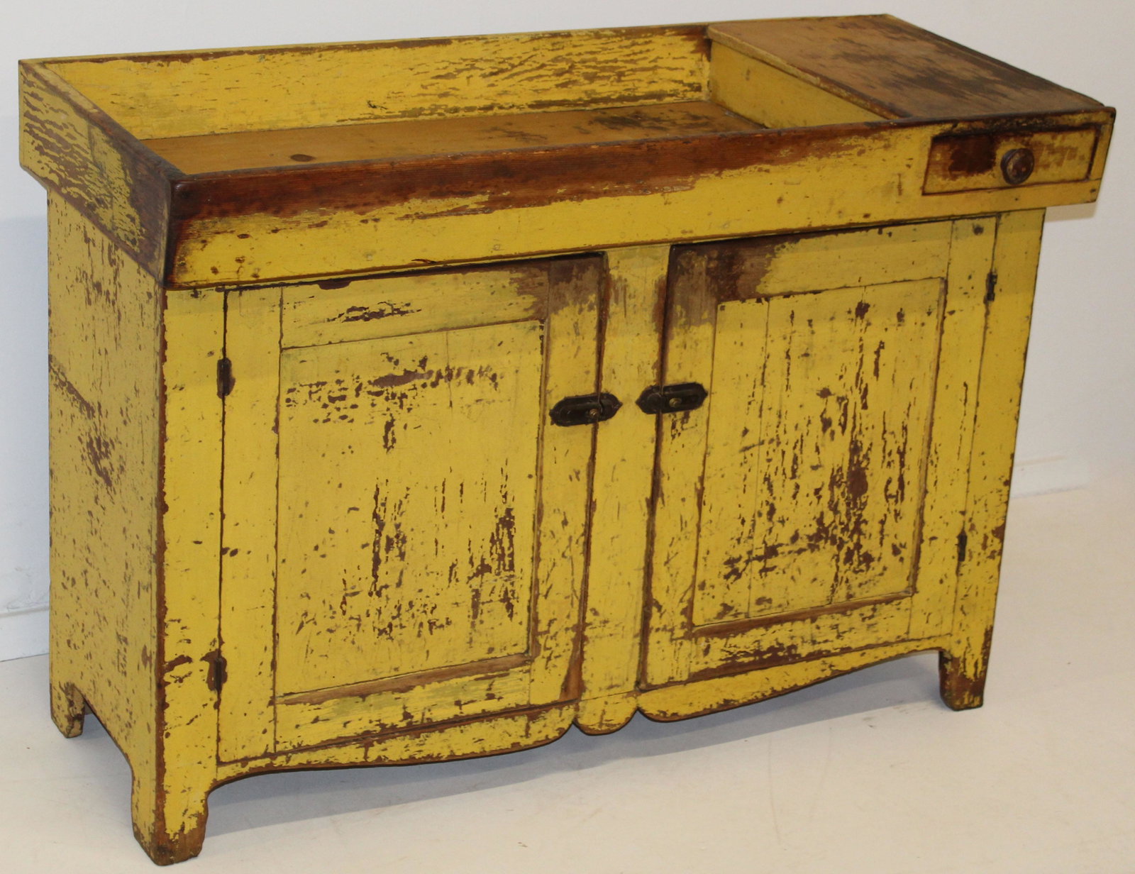 19th c New England dry sink in original yellow pt.: Early 19th c New England dry sink in original chrome yellow paint. Paneled lower doors, side drawer and canted sink. Worn yellow paint. 50" l, 21" deep, 35" high.