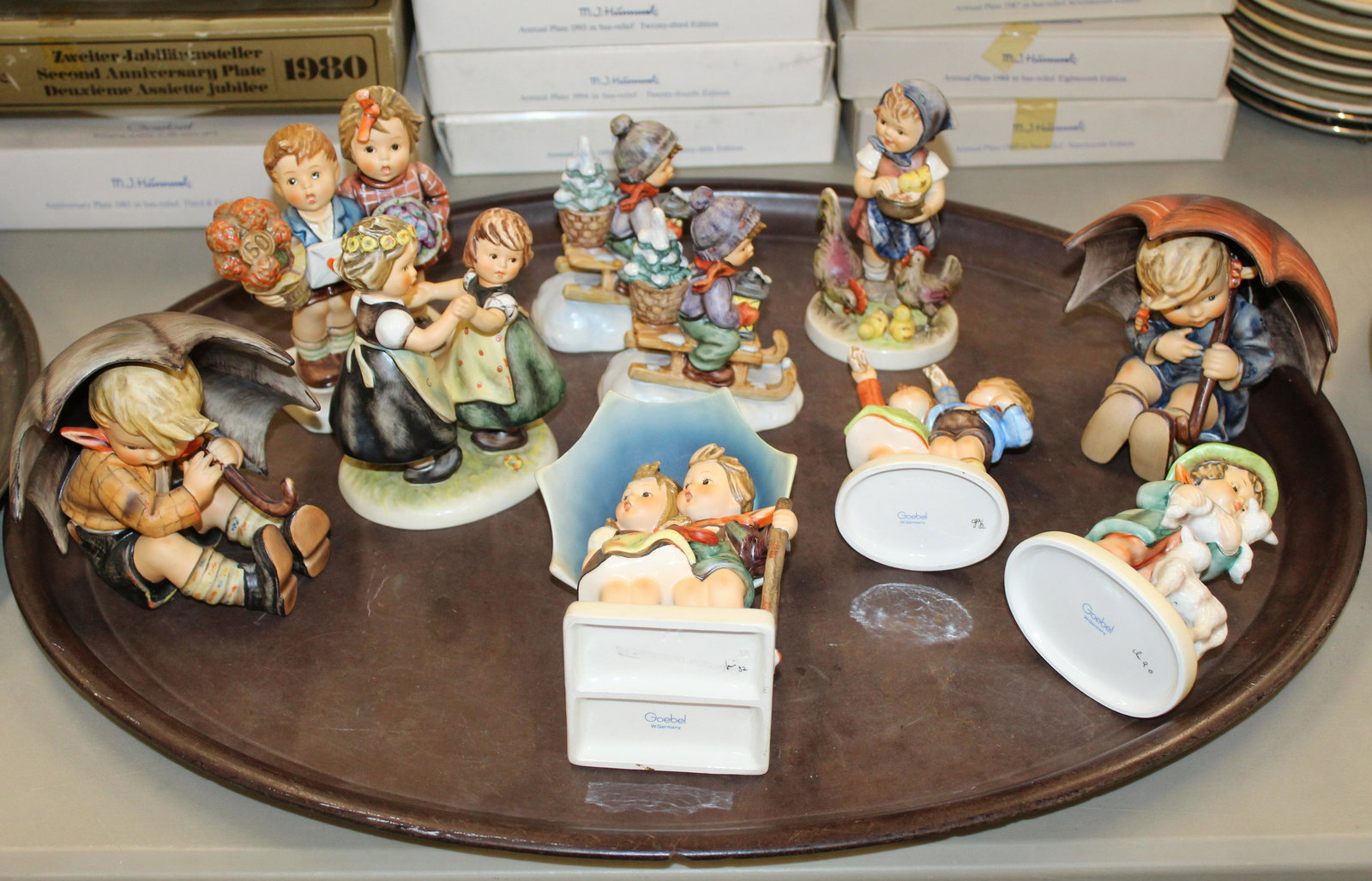 group of 10 larger Hummel porcelain figures: group of 10 larger Hummel Goebel porcelain figures including umbrella boy and girl, two sledding boy figures, Shepherd's Boy, others some with original boxes ht. 4.5"-6"