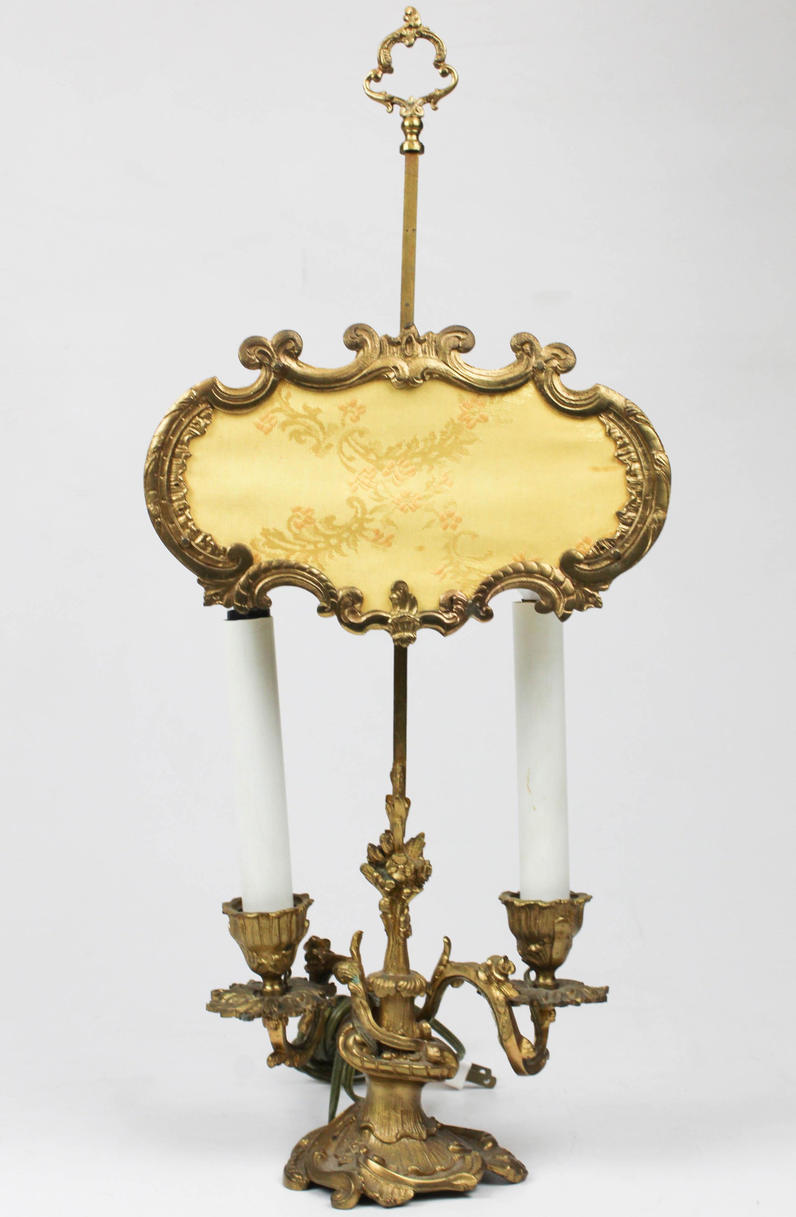French Ormolu Twin Branch Candlestick Lamp: French ormolu twin-branch candlestick lamp, with silk candle screen, electrified, overall ht 20 1/4"