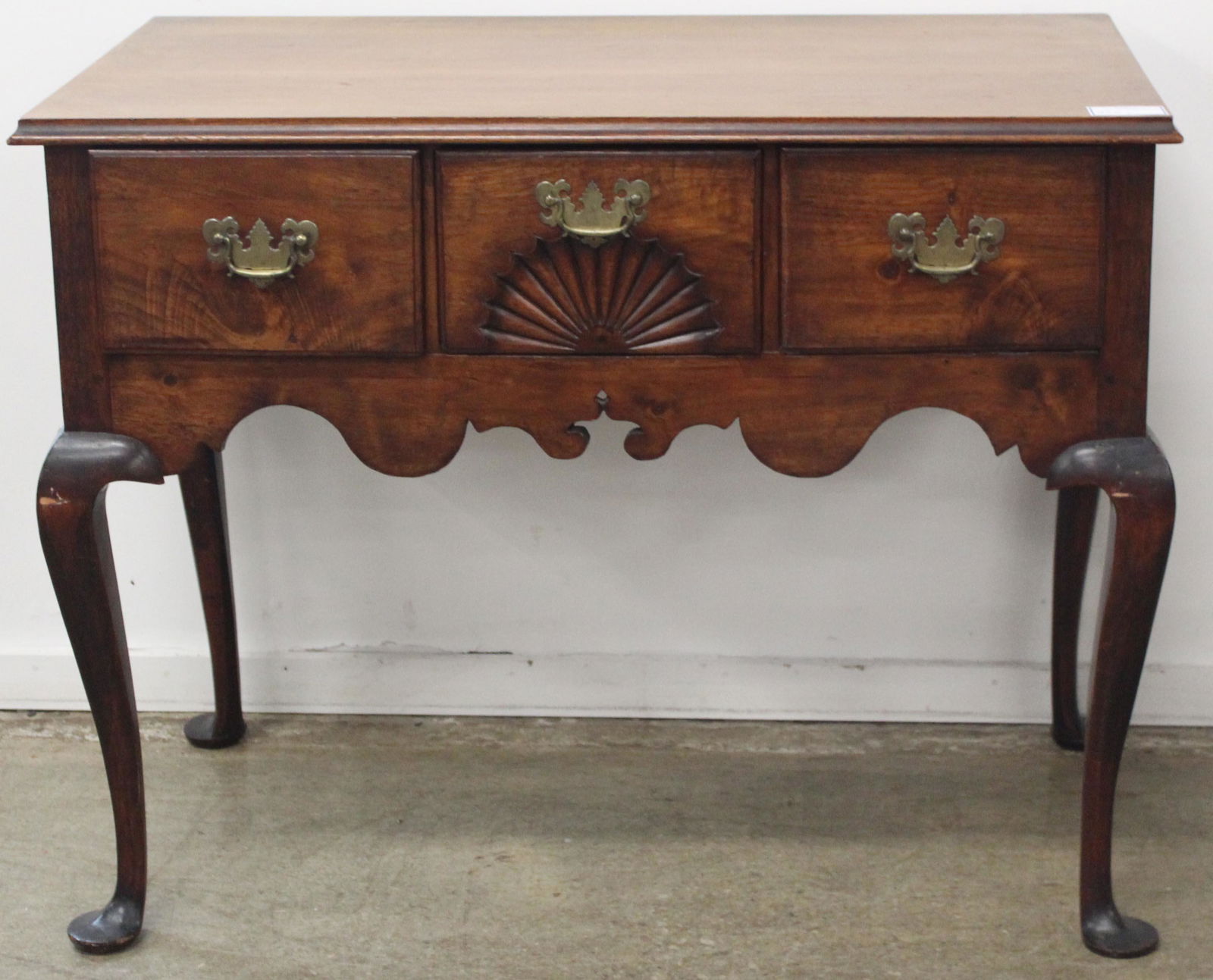 18th c. Queen Anne Walnut 3 Drawer Lowboy: 18th c. Queen Anne walnut 3 drawer lowboy with fan carved center drawer and shaped skirt, on cabriole legs terminating in pad feet, was formerly a highboy base with mahogany top added subsequently 30.