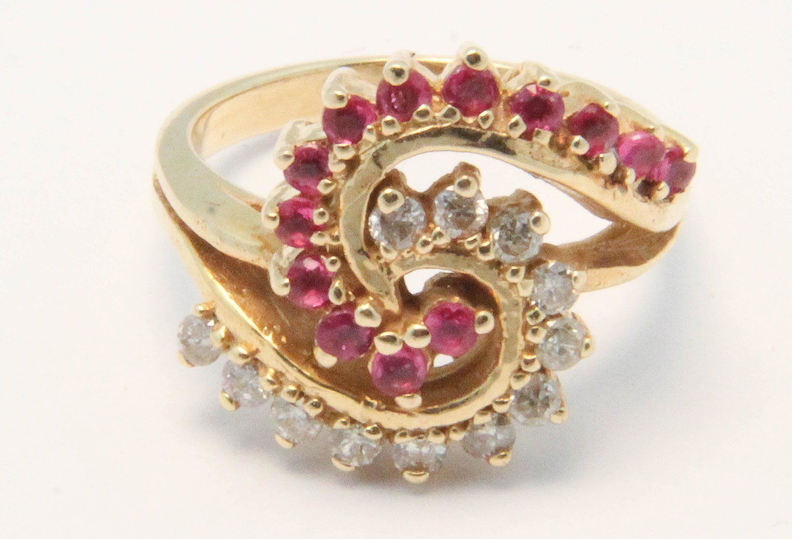 Ruby and diamond ladies ring: 14k yellow gold ruby and diamond cocktail ladies ring having two semi circles one with 12 .02 rd cut diamonds, other with 12 round cut .02 ct rubies. Ring size 6.5