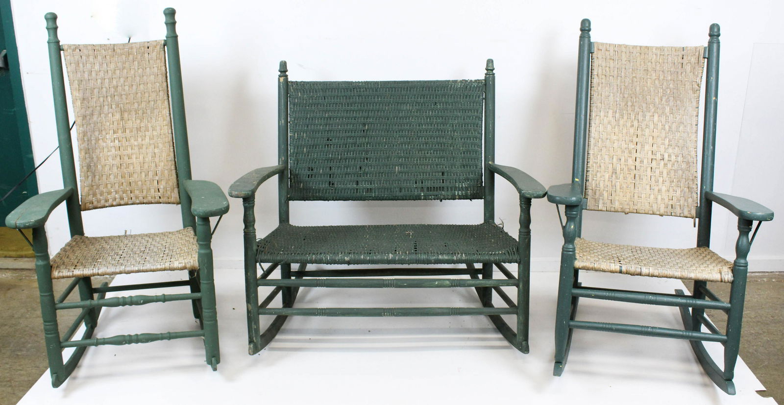 Pair of Woven Wicker Porch Rockers and Settee: Pair of Classic "Kennedy" style flat arm porch rockers with woven wicker backs and seats, accompanied by scarce double seater rocking settee -some damage and losses to wicker
