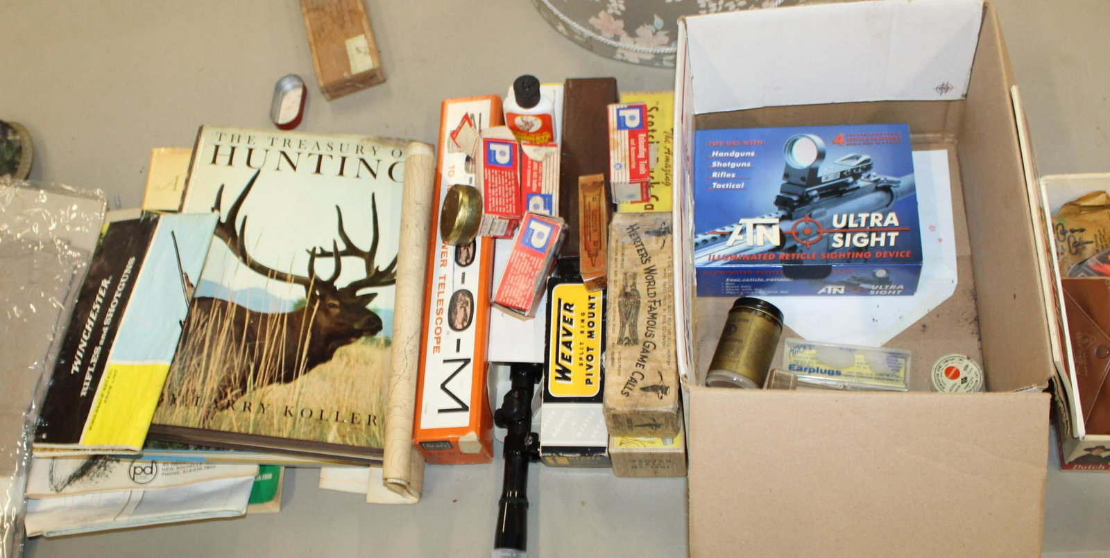 Large sporting lot: Large lot of sporting items including sights, vintage boxes and ephemera, 1940 US Military 1911 manual; two new old stock boxes of snowshoe bindings, scopes; fishing vests etc.