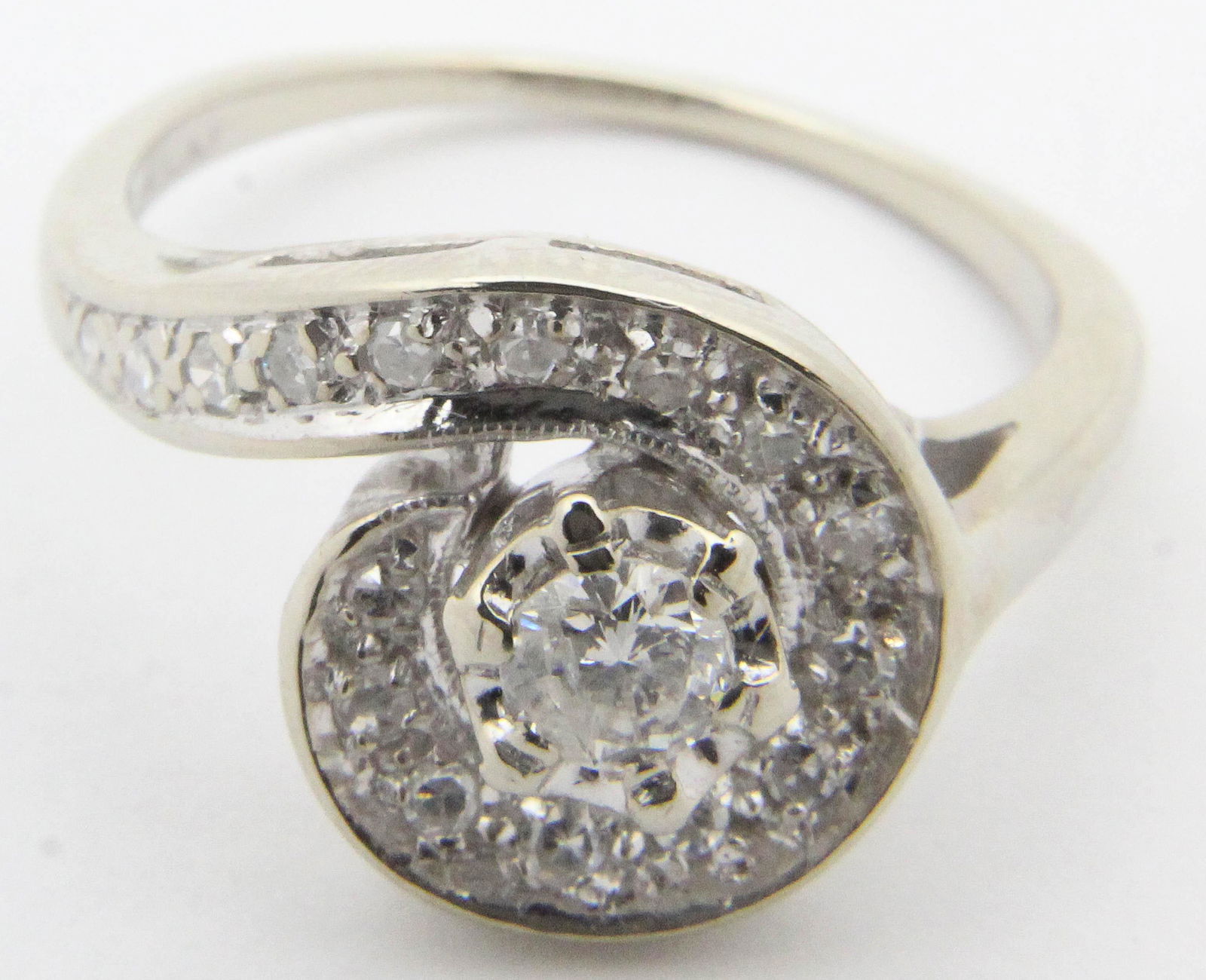 Modern 1 ct t.w. diamond ring: 14k white gold diamond ring with a 1/2 ct round cut diamond solitaire VS1 J color with a channel set band and surround of 18 .03 ct diamonds. Approx. 1 ct total weight. Ring size 8.