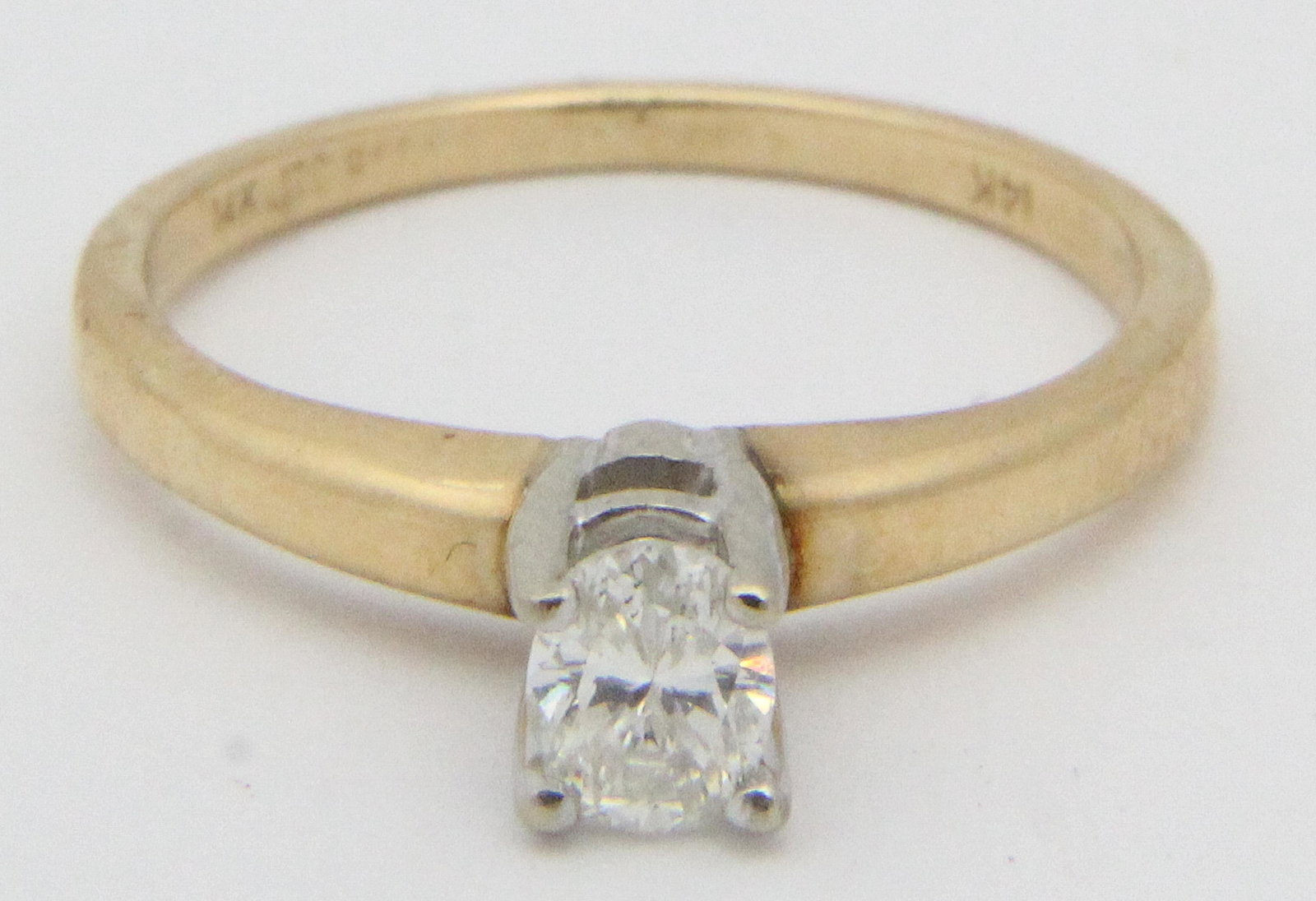 Diamond & 14k yellow gold engagement ring: A oval cut diamond and 14k yellow gold solitaire engagement ring. Diamond measuring 5 mm x 3.5 mm x 2 mm or .25 cts. . Ring size 6.