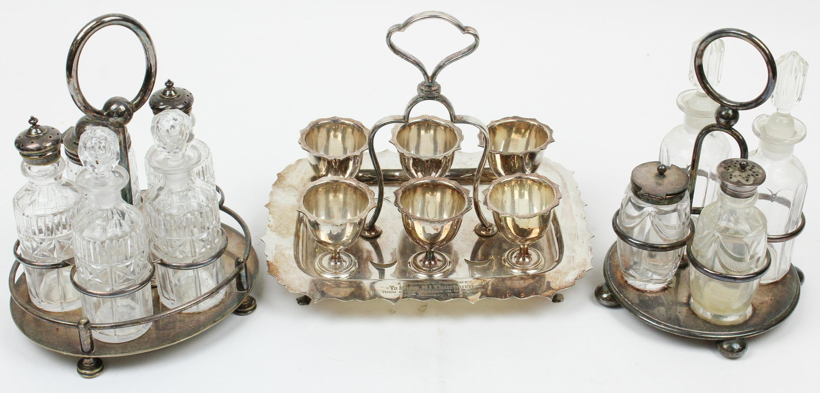 2 Silver-plated Caster Sets and Egg Cups: 2 Sheffield silver-plated caster sets with cut glass bottles and A.& J. Smith Aberdeen hard boiled egg serving caddy (one set has two replacement cruets) ht. 8.5"- 9.5"