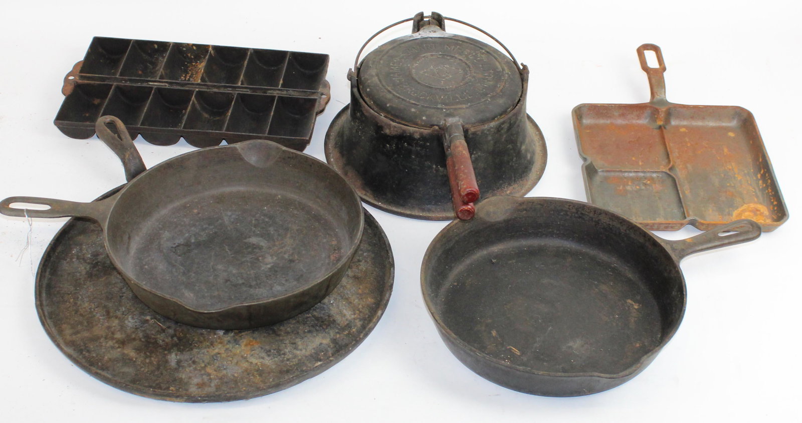 Lot of Cast iron including Griswold: James Smart waffle iron, Griswold large block logo Colonial Breakfast Skillet no. 666, unsigned no.8 Skillet, Griswold no. 8 704h skillet, Large Cast iron griddle.