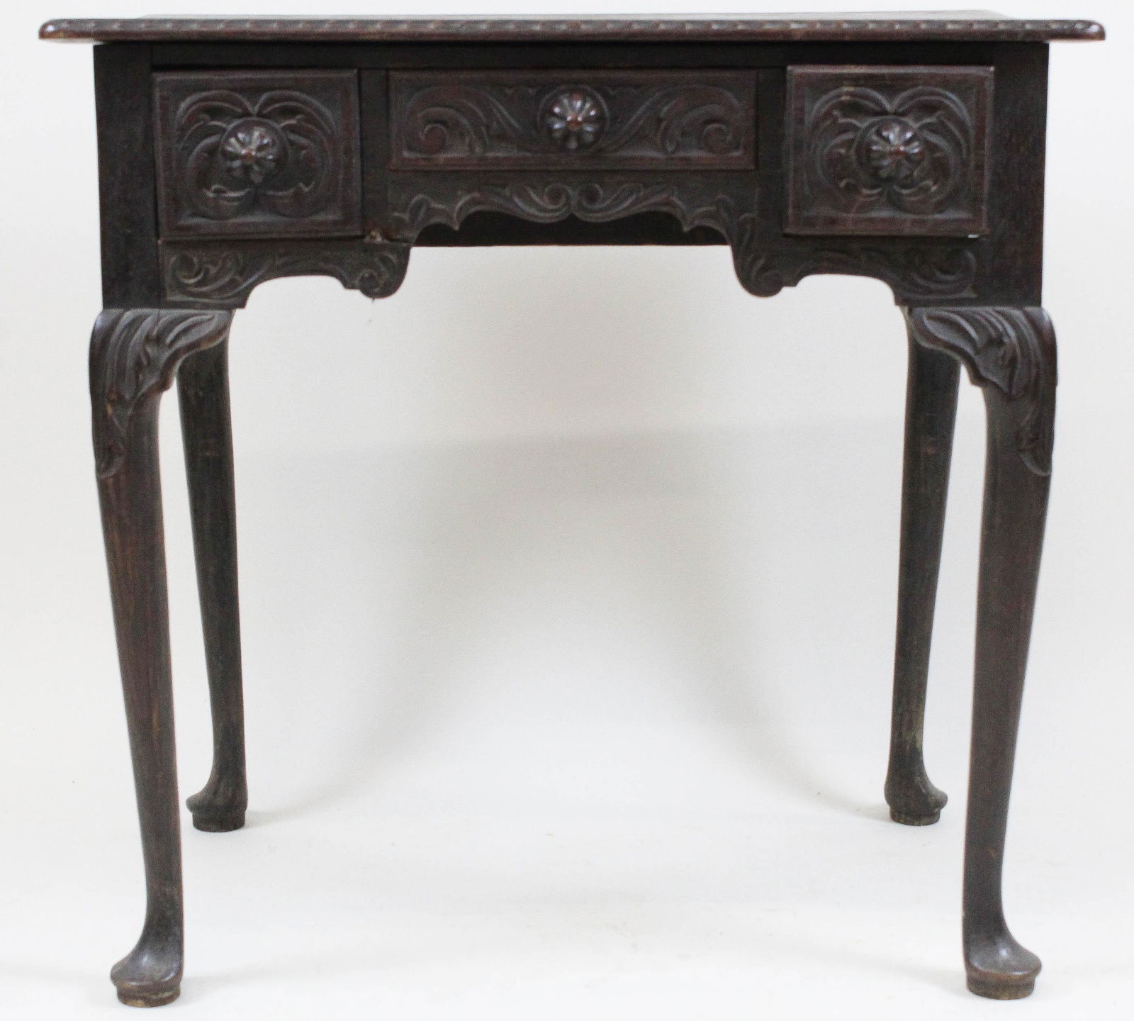 Petite George III oak lowboy: 19thc George III oak lowboy. Carved drawer fronts, carved original pulls, dragooned knees, Queen Anne foot. 28" wide.