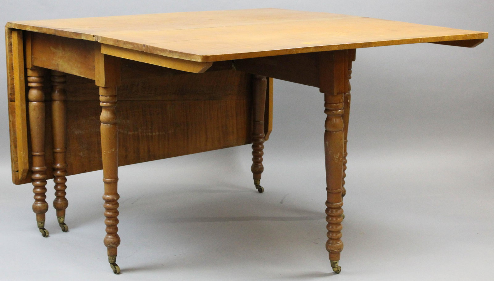 19th c Maple Deep Drop Leaf Table: 19th c Sheraton Tiger maple deep drop leaf table, top measures 66 x 46" extended or 23 x 46" folded.