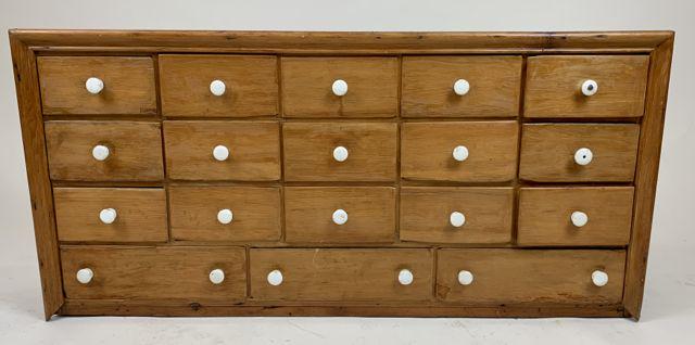 18 drawer apothecary cabinet.: 18 drawer 19th c pine refinished apothecary cabinet. White porcelain knobs, refinished front, grain painted ends. 45" long, 21" h, 9" deep.