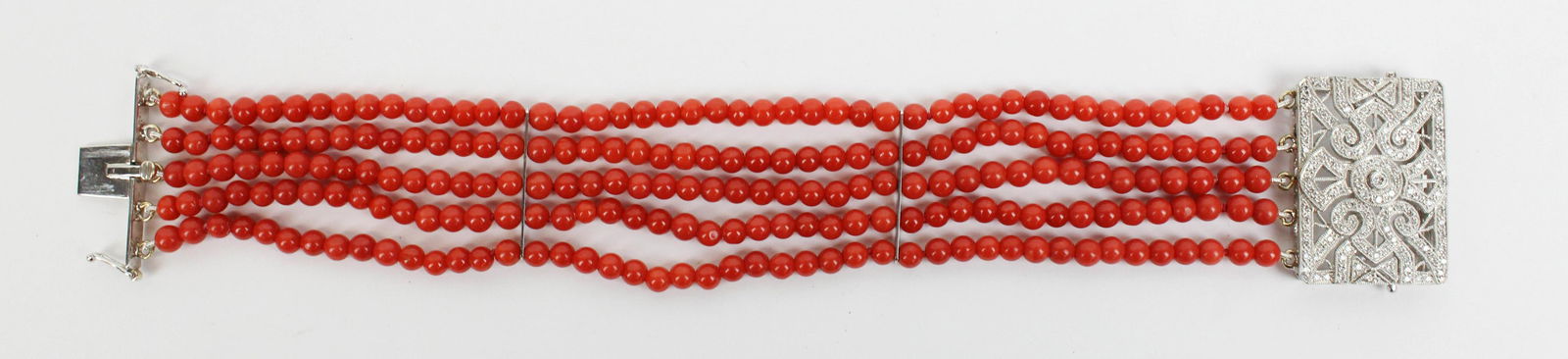Fine diamond and coral Art Deco style bracelet: Fine diamond and coral Art Deco style bracelet. 18k white gold clasp 1 1/8" x 3/4" rectangular set with a fine melee of diamonds approximately 1.25 carats. 7" long bracelet with 5 strains of 3.5 mm co
