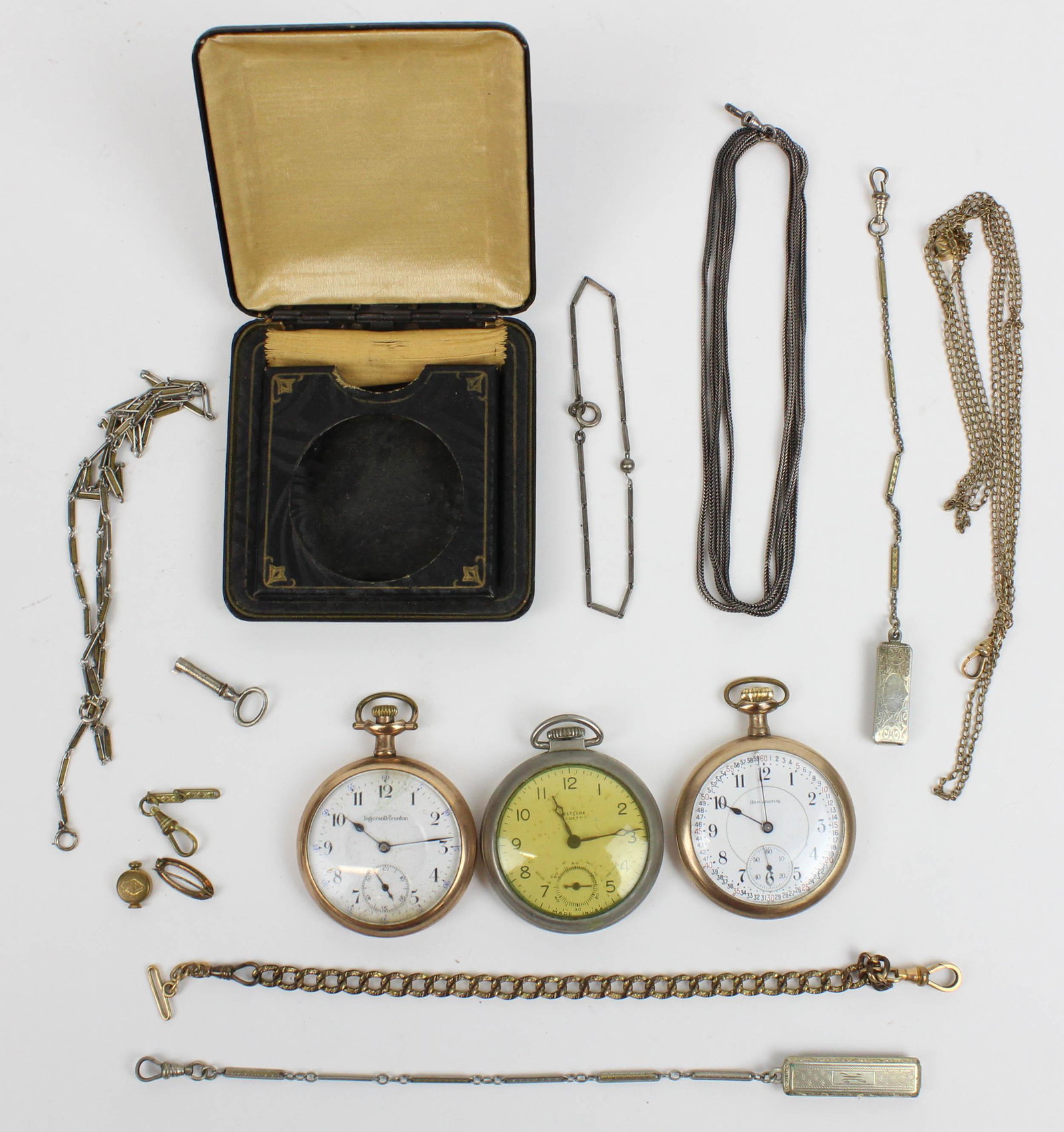 A group of pocket watches and chains: A group of 3 open face pocket watches including a Burlington, Ingersoll-Trenton, and a Westclox. Along with several Victorian watch chains.