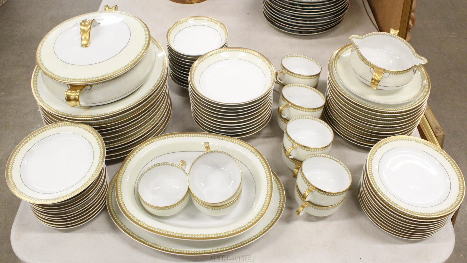 84 pcs. Haviland Limoges Porcelain Dinnerware: 84 pcs. ca. 1920 Haviland Limoges porcelain dinnerware with delicate crenellated yellow border and gold rim, including oval platter, serving bowl, covered dish, sauce boat, 12 dinner plates, side bowl