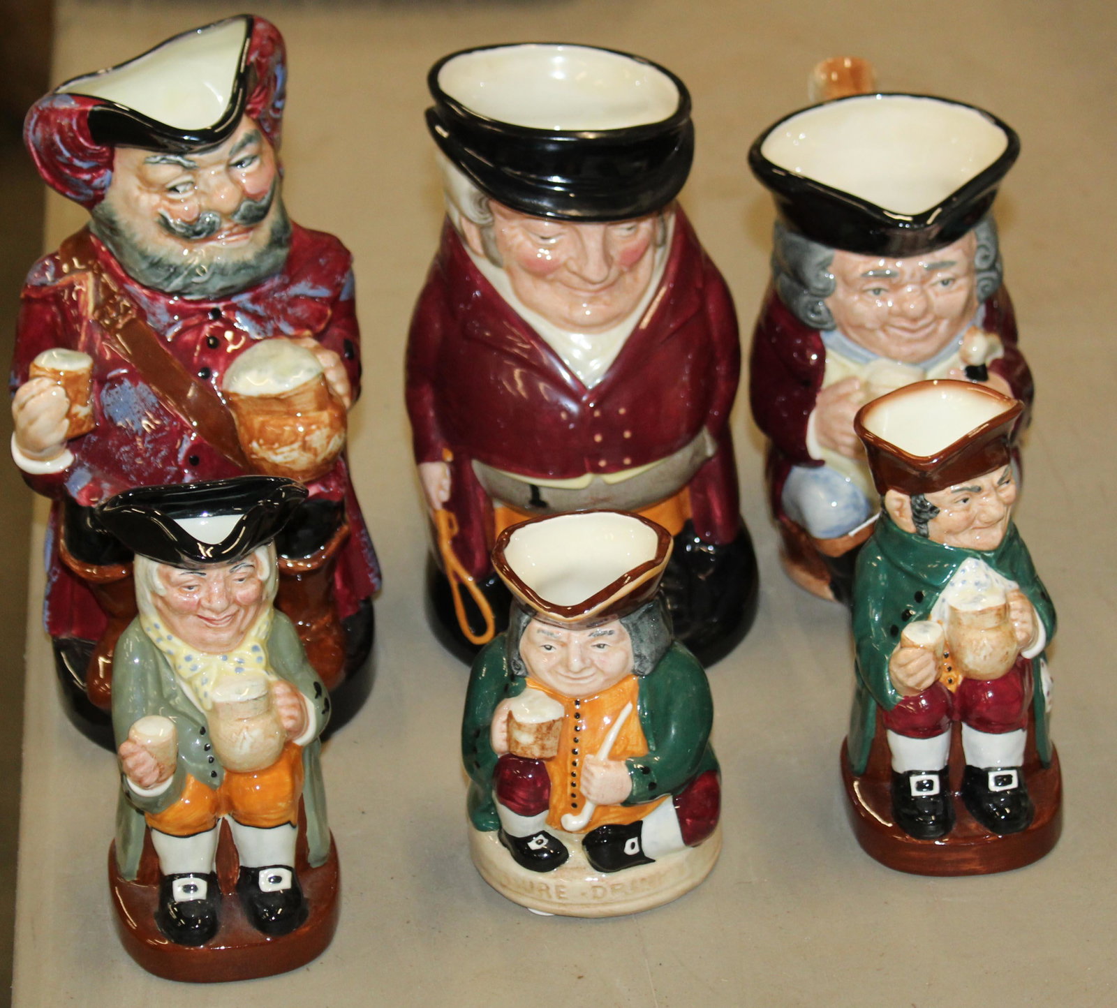 6 Royal Doulton Porcelain Classic Toby Jugs: Group of 6 graduated Royal Doulton porcelain classic toby jugs including Sir John Falstaff, The Huntsman, rare Jolly Toby (w/blue britches), Happy John, Old Charlie, Honest Measure ht. 4"-9"