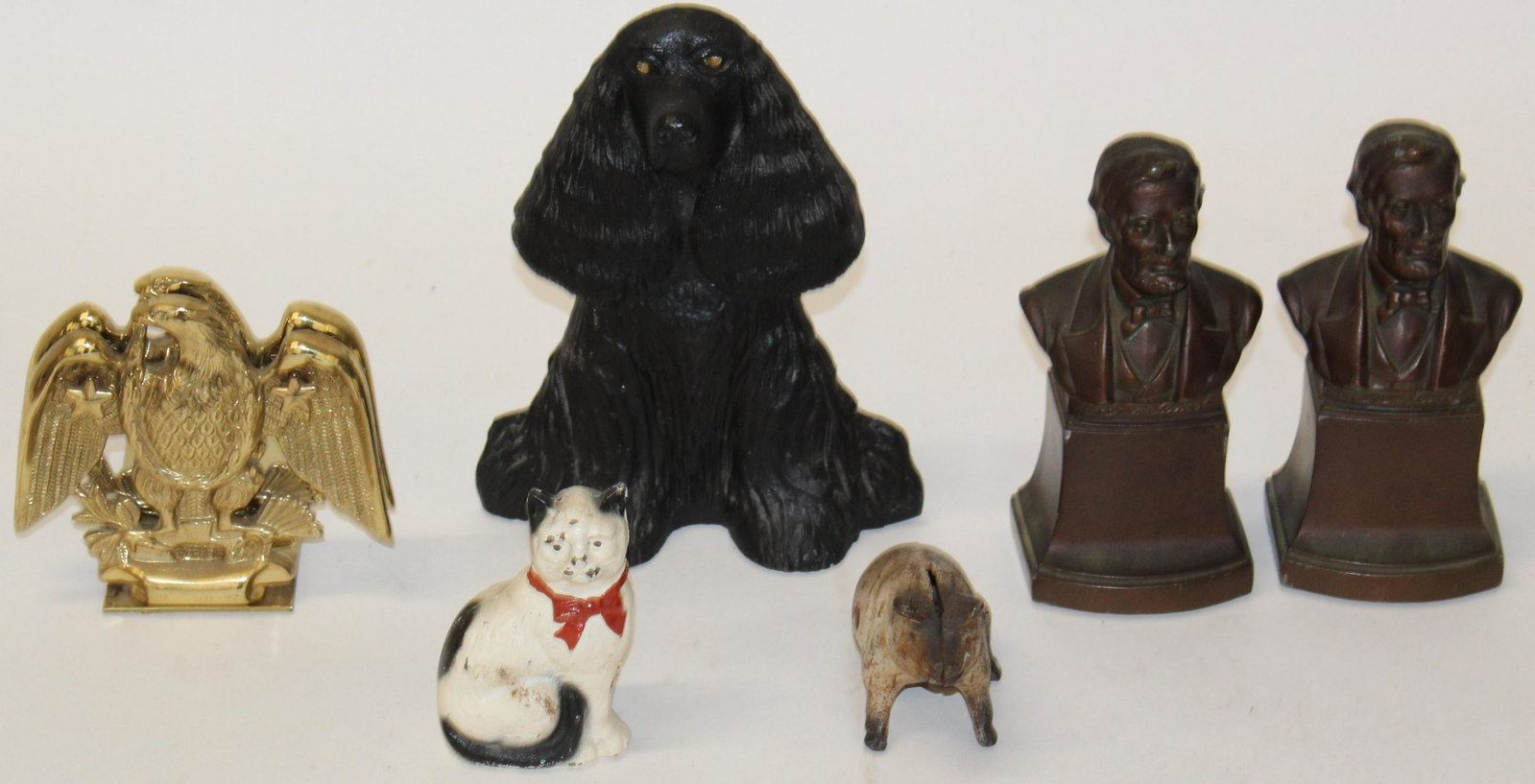 Cast Iron Door Stop, Two Pairs of Bookends: Group of metalware accessories including late 20th c. cast iron spaniel dog doorstop, pair of patinated pot metal Lincoln bookends, and pair of Baldwin American eagle polished brass bookends, two late
