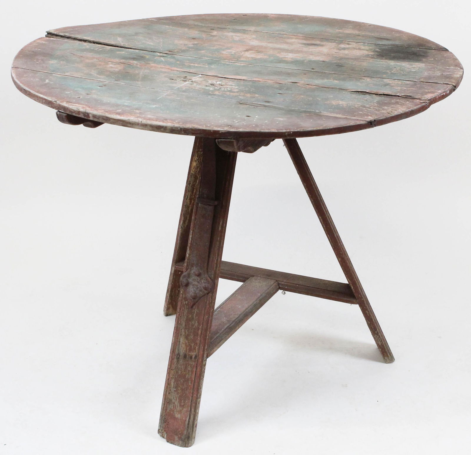 Primitive tilt top tea table on original red surface: Early 19th c New England tilt top tea table. Round 4 board maple top in old green and red paint set on to a box with tilt pins. Large iron strap lock for top. Tripod molded legs with pegged T molded s