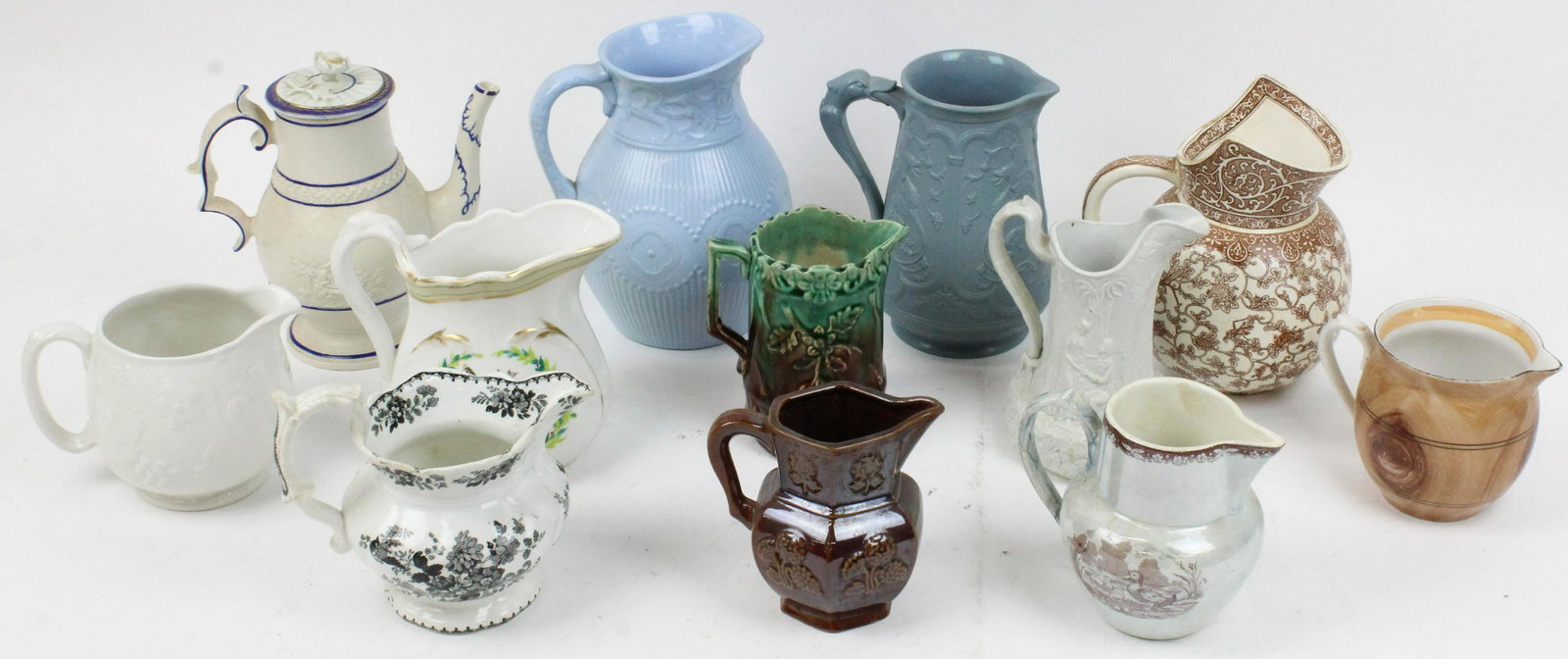 Collection of 12 Pottery Pitchers and Creamers: Collection of 12 Pottery Pitchers and Creamers including Doulton Burslem calico transferware, ironstone jug with handpainted 1776 patriotic cartouche, majolica, faux bois painted, early black transfer