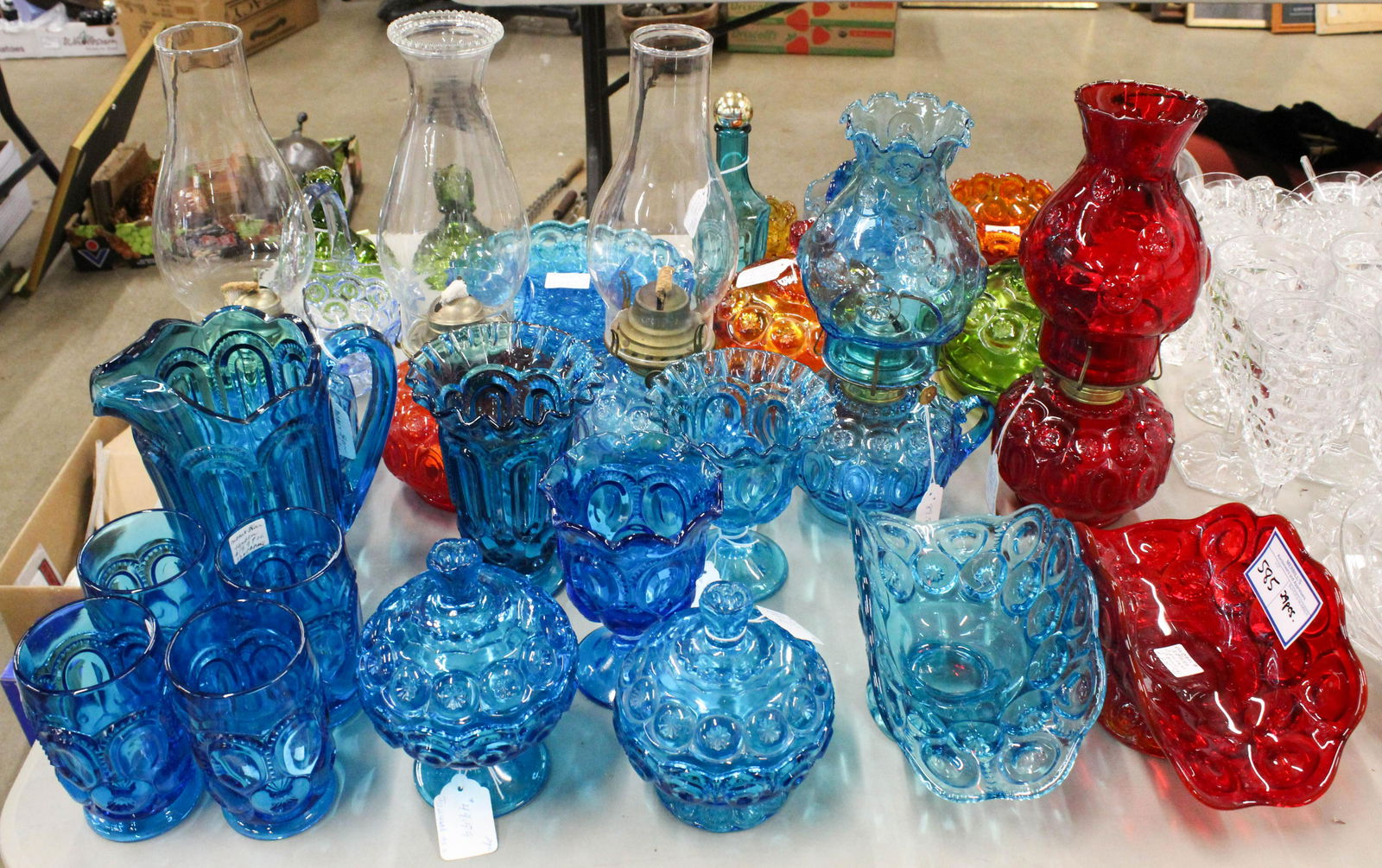 29 pcs. Moon and Star Pattern Colored Glassware: Group of 29 pcs. L.E. Smith Moon and Star Pattern Glassware in blue, red, green and orange colors including oil lamps, round covered butter dishes, basket, covered dishes, tumblers, divided dishes and