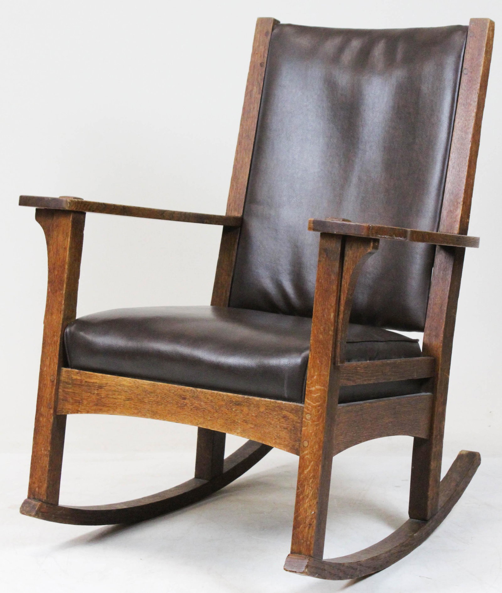 L & J G Stickley High Back Rocker: L & J G Stickley high back oak arm rocking chair. Red clamp mark decal on back. 5 horizontal back slats, arched stretchers. Original surface, replaced seat cushions. 40" h x 20" w x 20" d