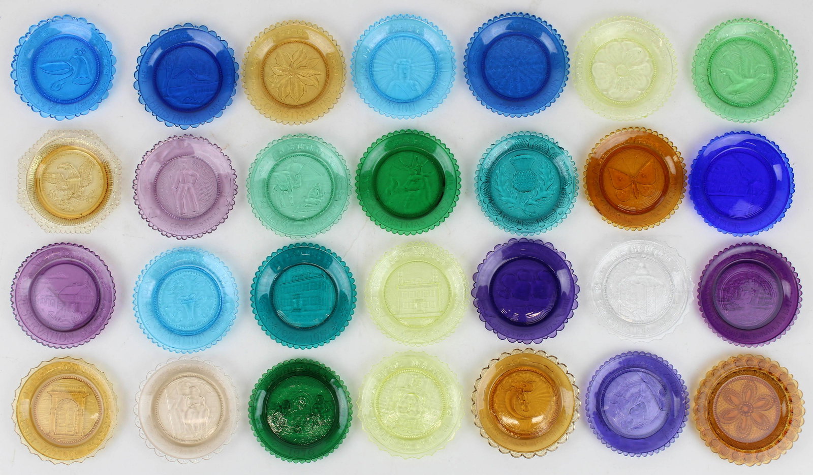 Collection of 28 Pairpoint Glass Cup Plates: Collection of 28 Pairpoint Glass EAPG replica glass cup plates, in various vivid colors featuring commemorative scenes, accompanied by custom pine display rack 3.5" dia.