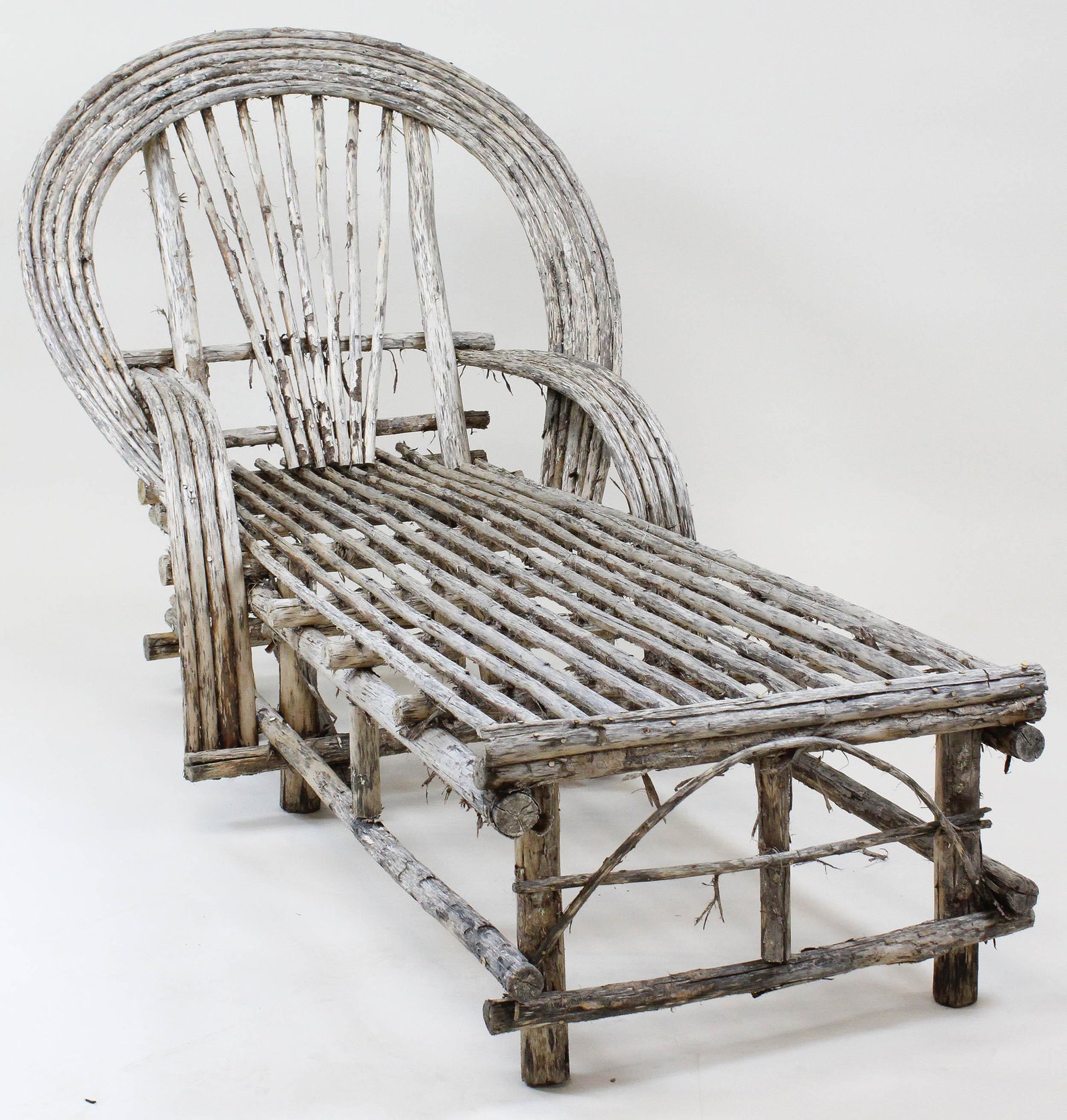 Adirondack Twig Chaise Lounge: Adirondack early 20thc bent twig chaise type lounge chair. Nailed twig construction. 5 bent rows for back and 4 bent rows for arms. Shag bark ruminates. Very good overall condition. 5 feet long, 36" w