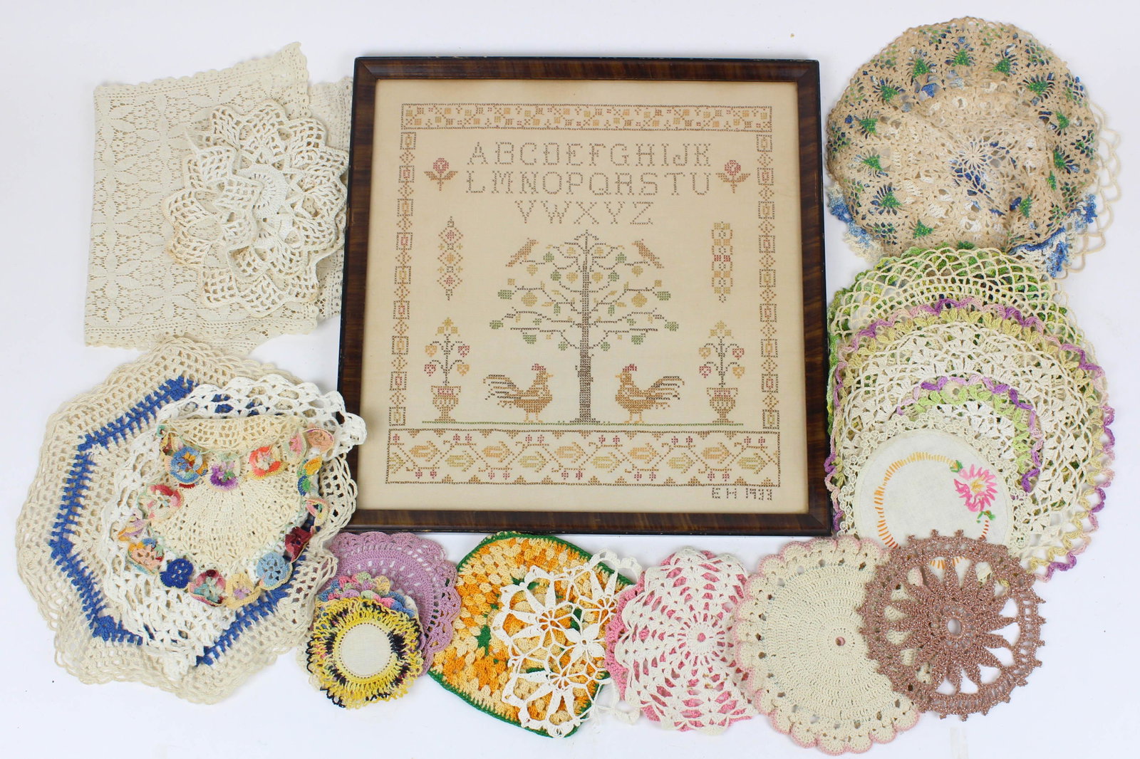Lot of Vintage Table Linens and Needlework: Lot of Vintage Table Linens and Needlework including crocheted doilies, lace tablecloths, framed 1933 sampler by Mrs. E. Hinckley, etc.