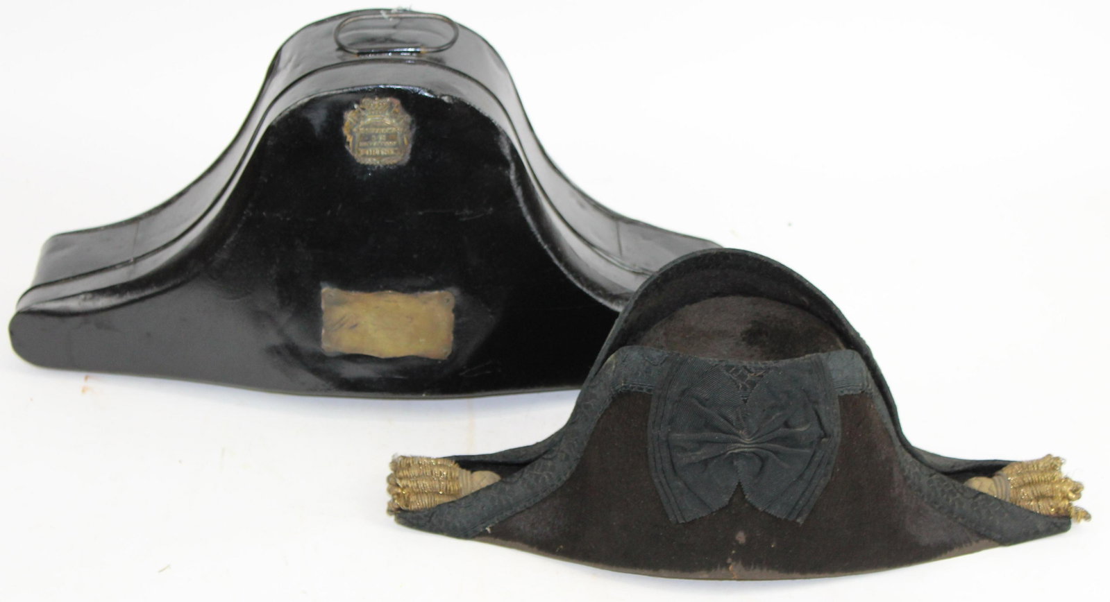 British Naval Bicorne Hat in tin case: Turn of the 19th c British Naval Cocked or Bicorn Officers Hat in tin case with un engraved plate on exterior marked Matthews & Co Outfitters Portsea. 19" long