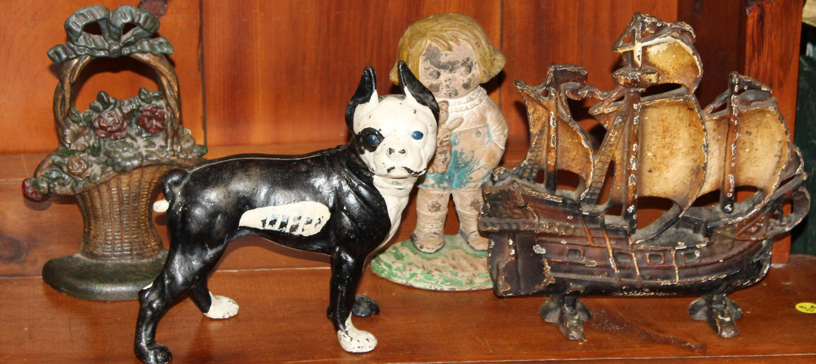 Four Antique Doorstops: Hubley Dingle "Bobby Blake" doorstop, Repainted Boston Terrier Doorstop, Bouquet doorstop and Ship Doorstop. 11"