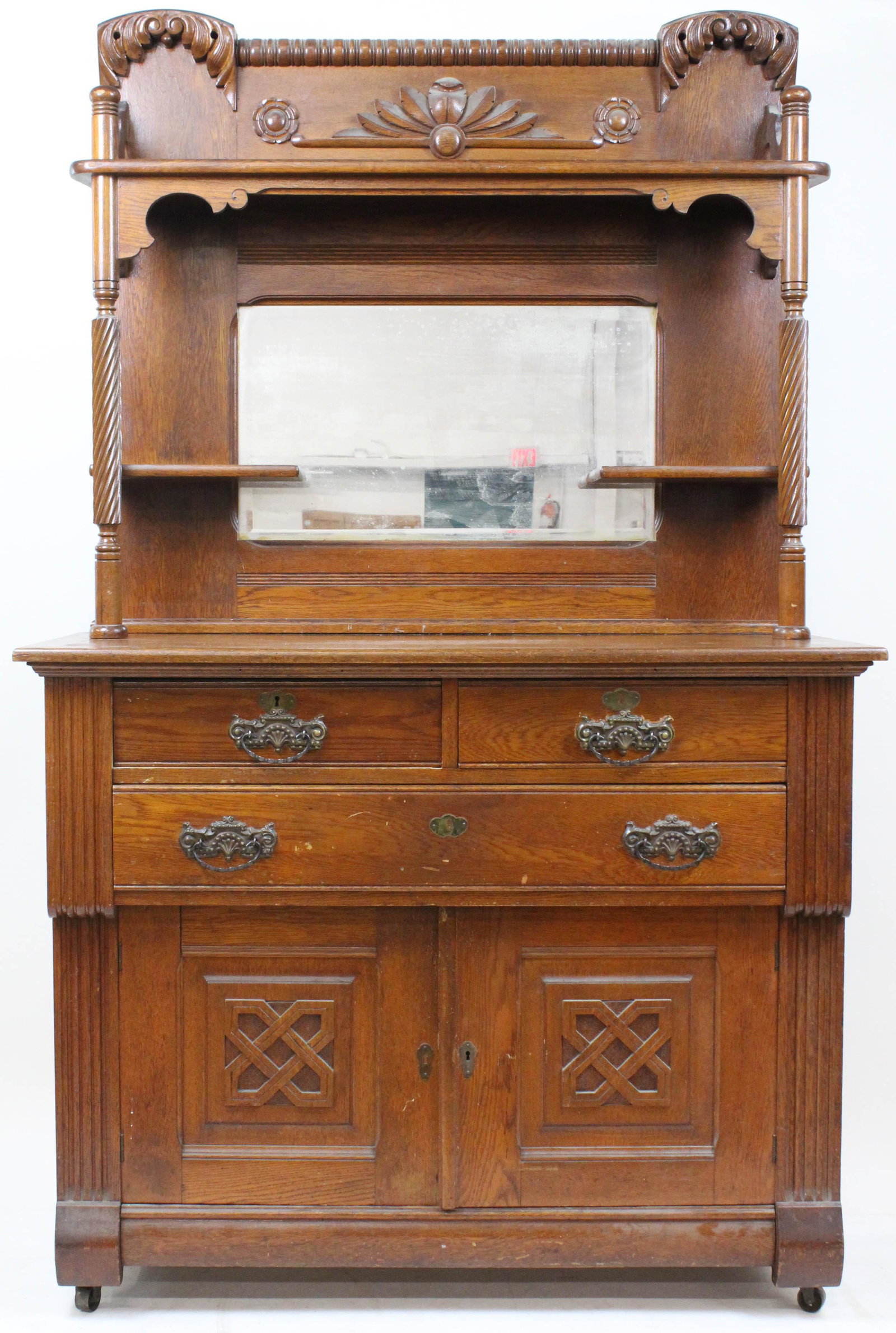 Victorian Oak Sideboard: Ornate Victorian oak mirror back side boards. Rope twist, beveled mirror back, multi tier upper section over 3 drawers and two doors. Original surface, original brasses, very good overall condition. 4