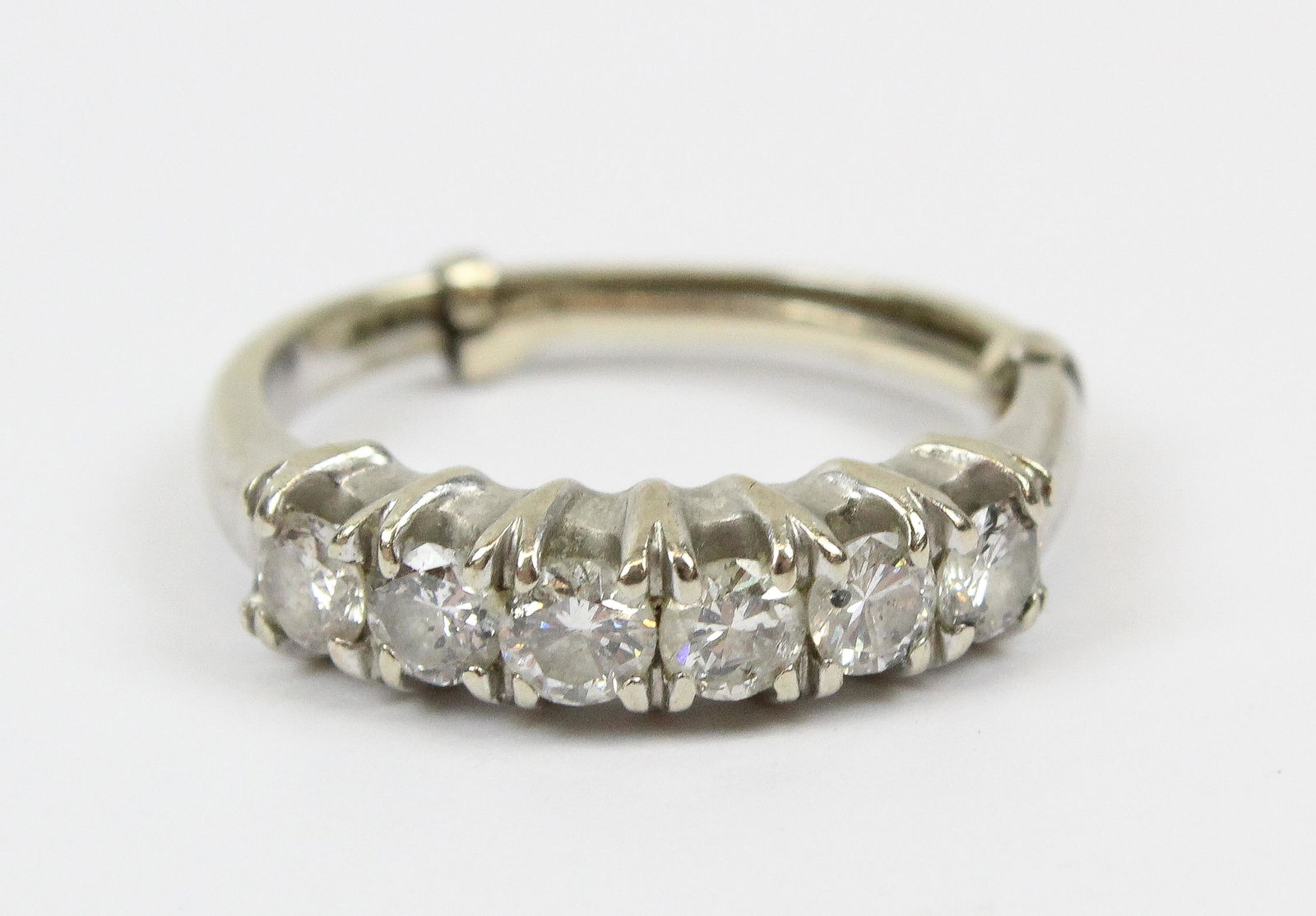 14k White Gold & Diamond Wedding Band: 14k w.g. wedding band set with 6 round cut diamonds each .15 cts. .9 cts.t.w. Ring size 7.5 with sizer.