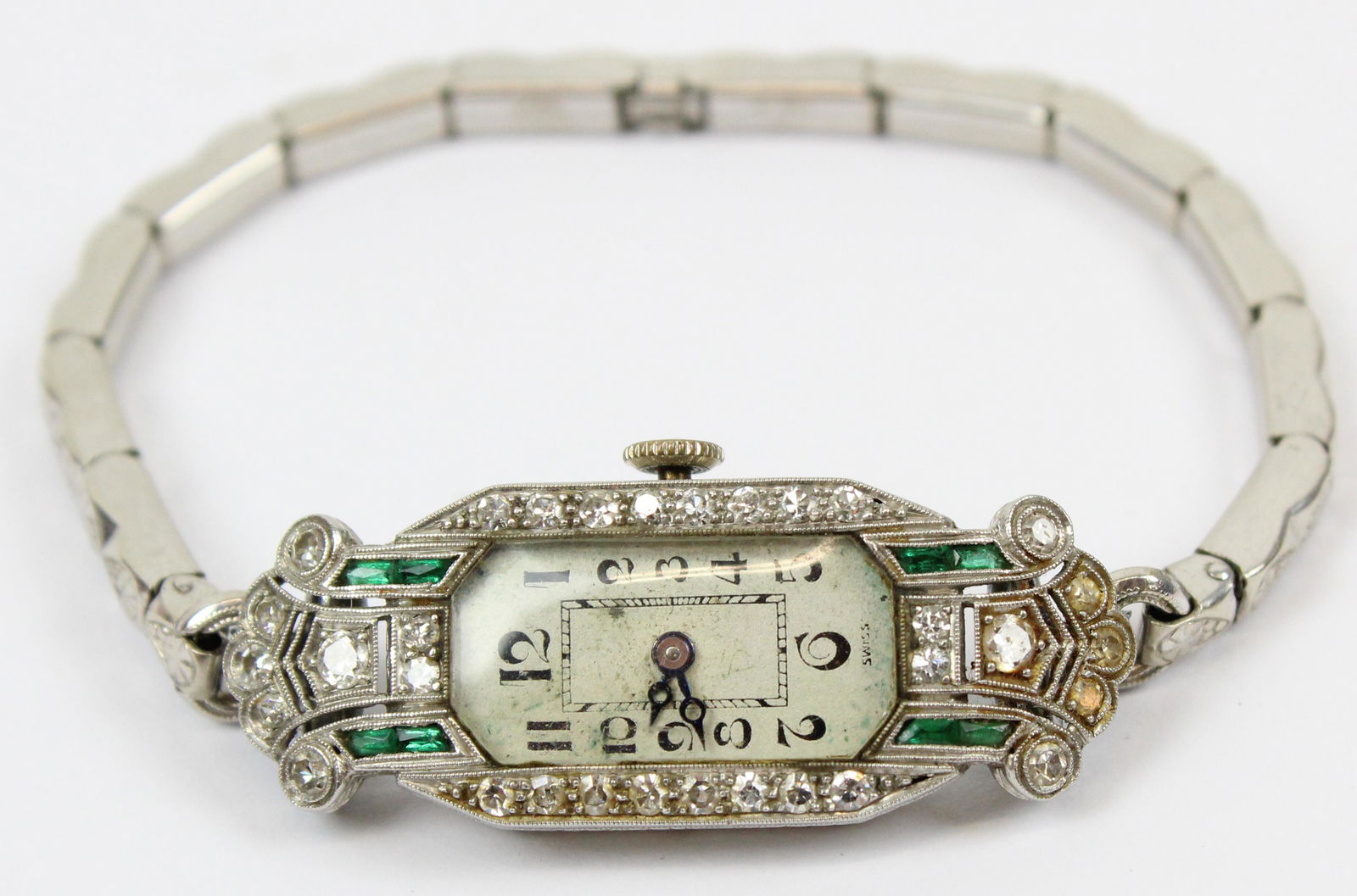 Ormont Swiss Diamond, Platinum, & Emerald watch: A Swiss Ormont & Co. Art Deco platinum ladies wrist watch set with diamonds and emeralds. Signed 17 jeweled movement. Rectangular case & hinge point 15 mm wide, 45 mm long. Case set with 32 small .01