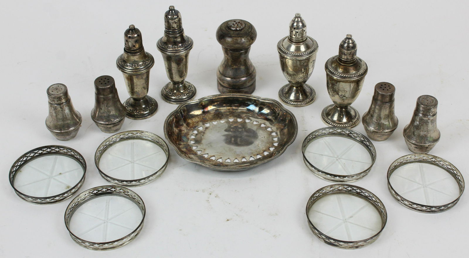 Group of Sterling Silver Jacketed Tableware: Group of Sterling Silver Jacketed Tableware including 4 sets of weighted salt and pepper shakers, single sterling shaker, set of 6 sterling banded cut glass coasters, accompanied by a silverplated hea