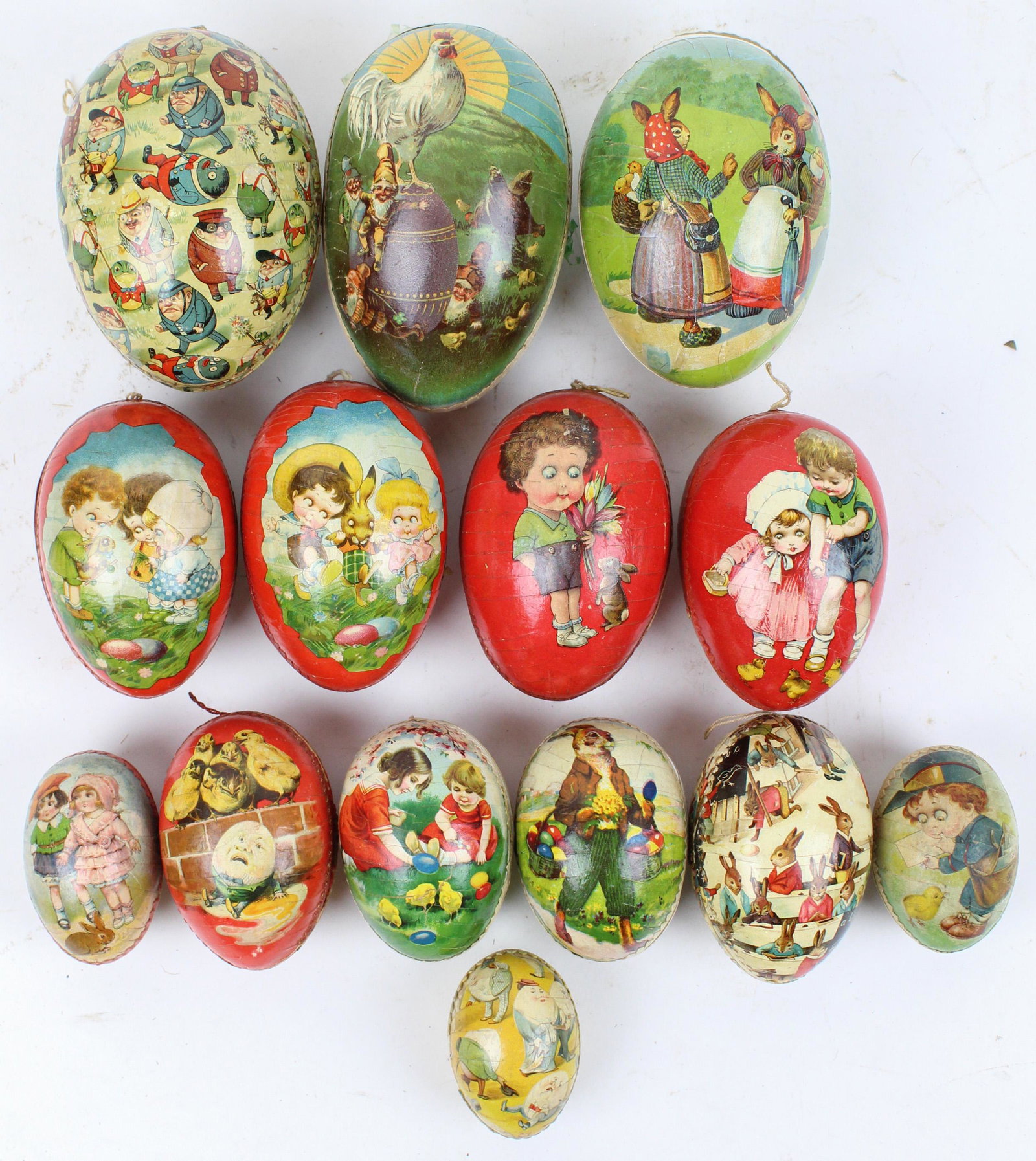 14 Easter Egg Candy Containers: 14 small to medium Easter Egg Candy Containers, including very interesting subjects, color litho with Dresden trim, paper mache and boxboard, lengths 2 1/2" to 5 1/2", some with trim losses