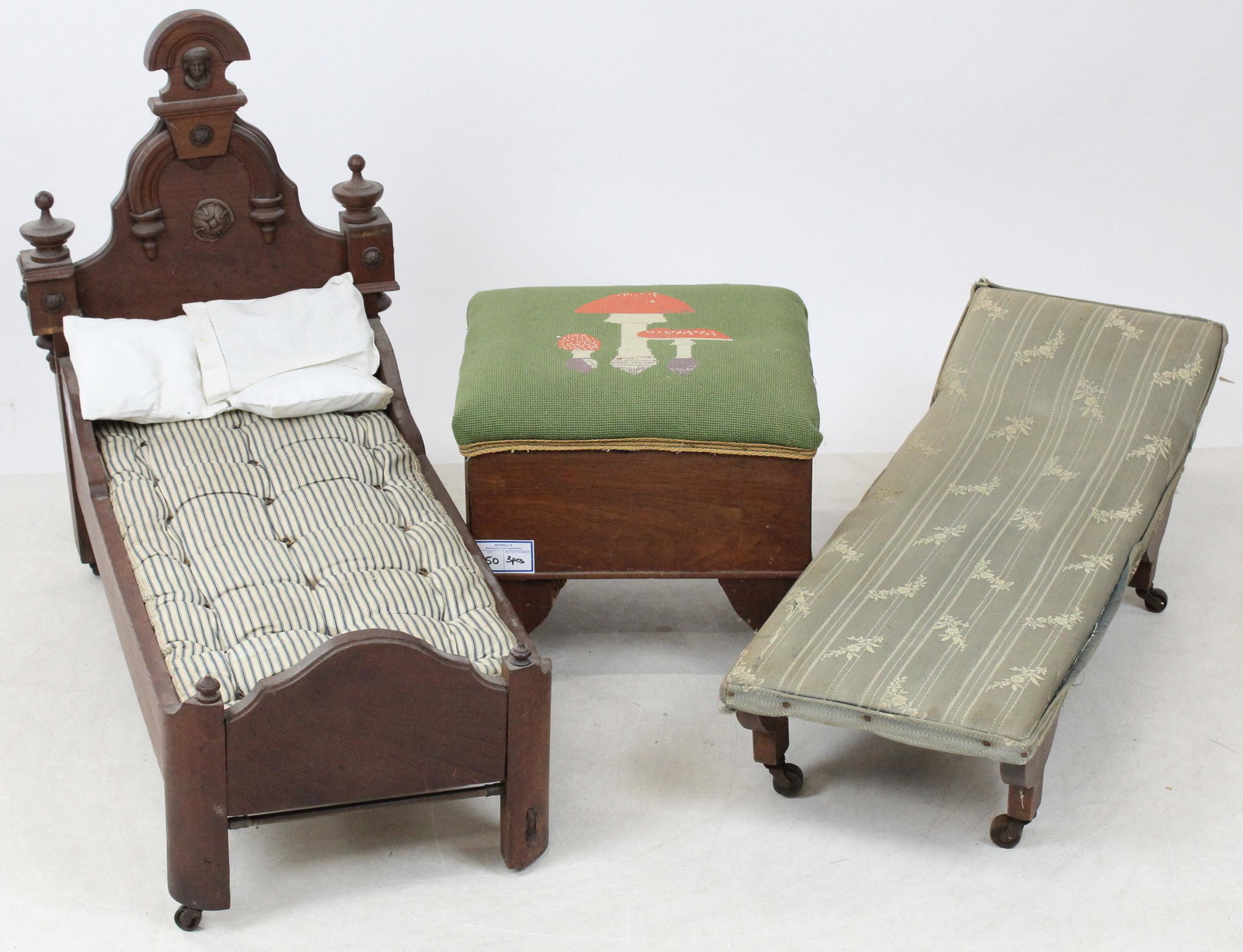 Walnut Doll Bed, Recamier, and Footstool: Victorian Black Walnut highback doll bed with figurehead, doll recamier fainting couch, and footstool with needlepoint mushroom upholstery 27" x 32" x 17", 34" x 11.5"x 13", 13" x 12" x 15"