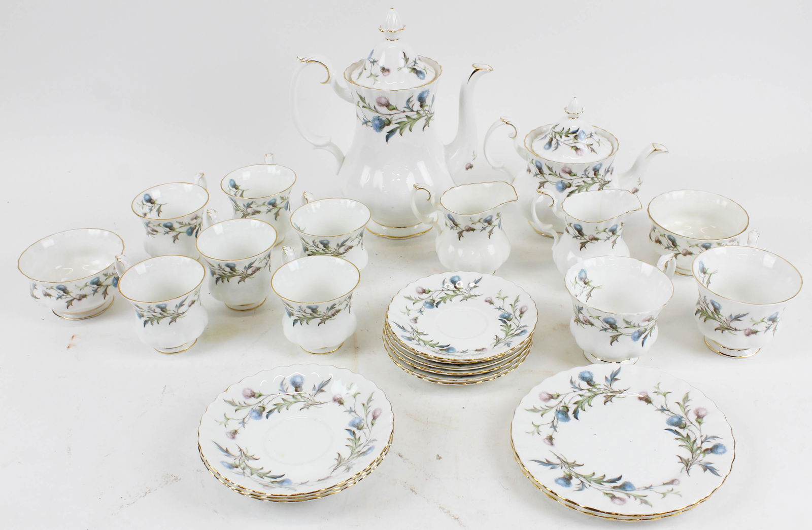 25 pcs. Royal Albert Brigadoon Porcelain: 25 pc. Royal Albert "Brigadoon" pattern fine English bone china porcelain tea set with Scottish thistle motif decoration including teapot, 2 sugar and creamer sets, cups of various sizes