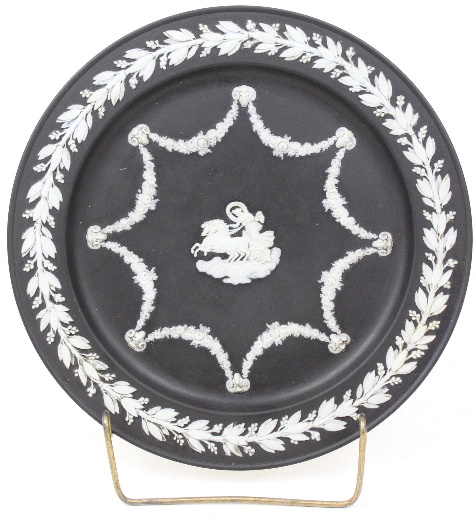 Wedgwood Jasperware Black Dip Charger Plate: Late 19th c. Wedgwood Jasperware black dip charger plate with applied neoclassical relief of floral festoons with rams head supports, surrounded by laurel border dia. 9.75" -sold to benefit the Vermon