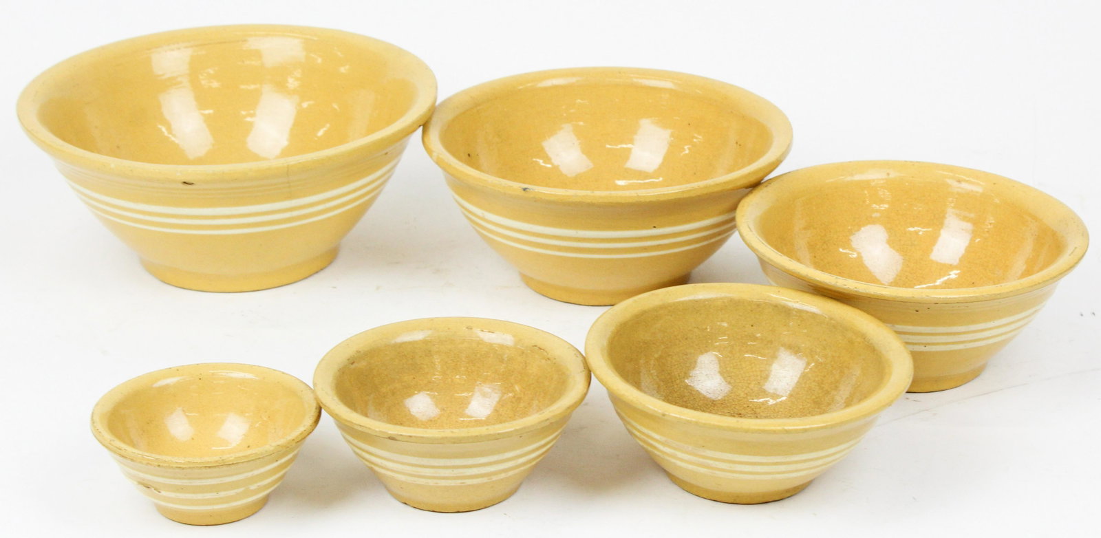 Nest of 6 Yellowware Pottery Banded Mixing Bowls: Nest of 6 yellowware earthenware pottery mixing bowls, some small checks, crazing, small rim chips dia. 4.25"-10"
