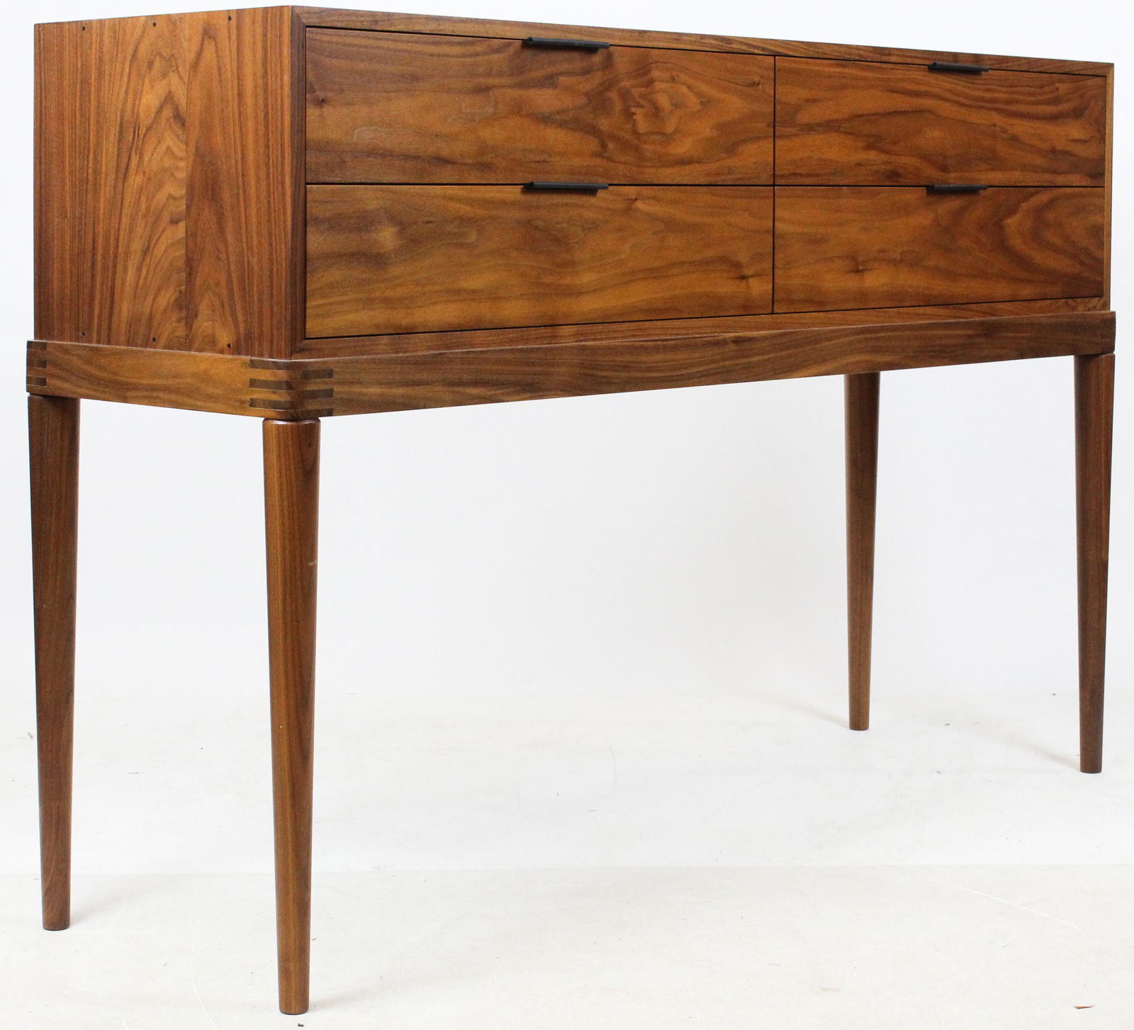 Thomas Moser Sideboard: A black walnut Thos Moser 4 drawer sideboard. 4 drawer rectangular case with leather tab pulls, curved multi-tendon edge, 4 tapered peg legs. Cumberland Sideboard. 39"h, 58"w, 17"l.