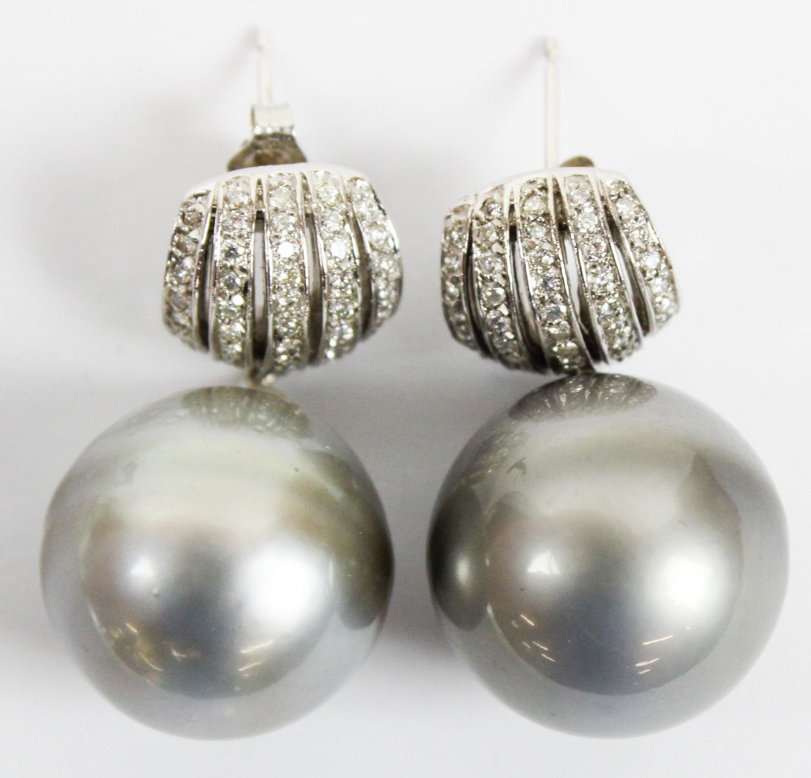 South Sea Pearl & Diamond Earrings: Fine pair of natural grey south sea pearl earrings 18mm dia. set on a loop below a 18k white gold group of 5 rows of 9 .01 to .02 ct diamonds. Approx 1 ct plus total weight diamonds. Earrings are 1 1/